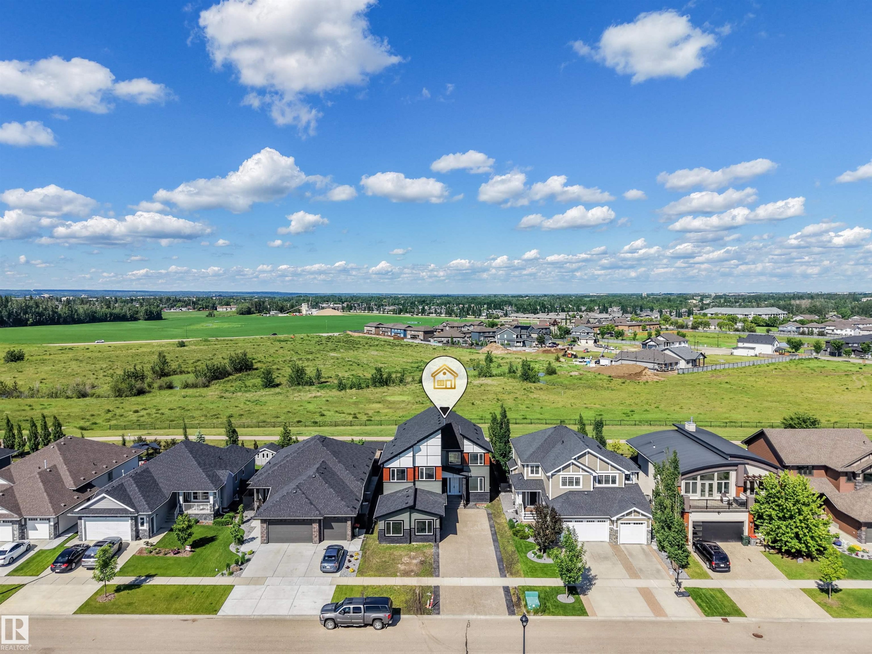 Contemporary two-story residence featuring a gray and red exterior with a prominent A-frame roofline - 1180 Genesis Lake Boulevard, Stony Plain, AB