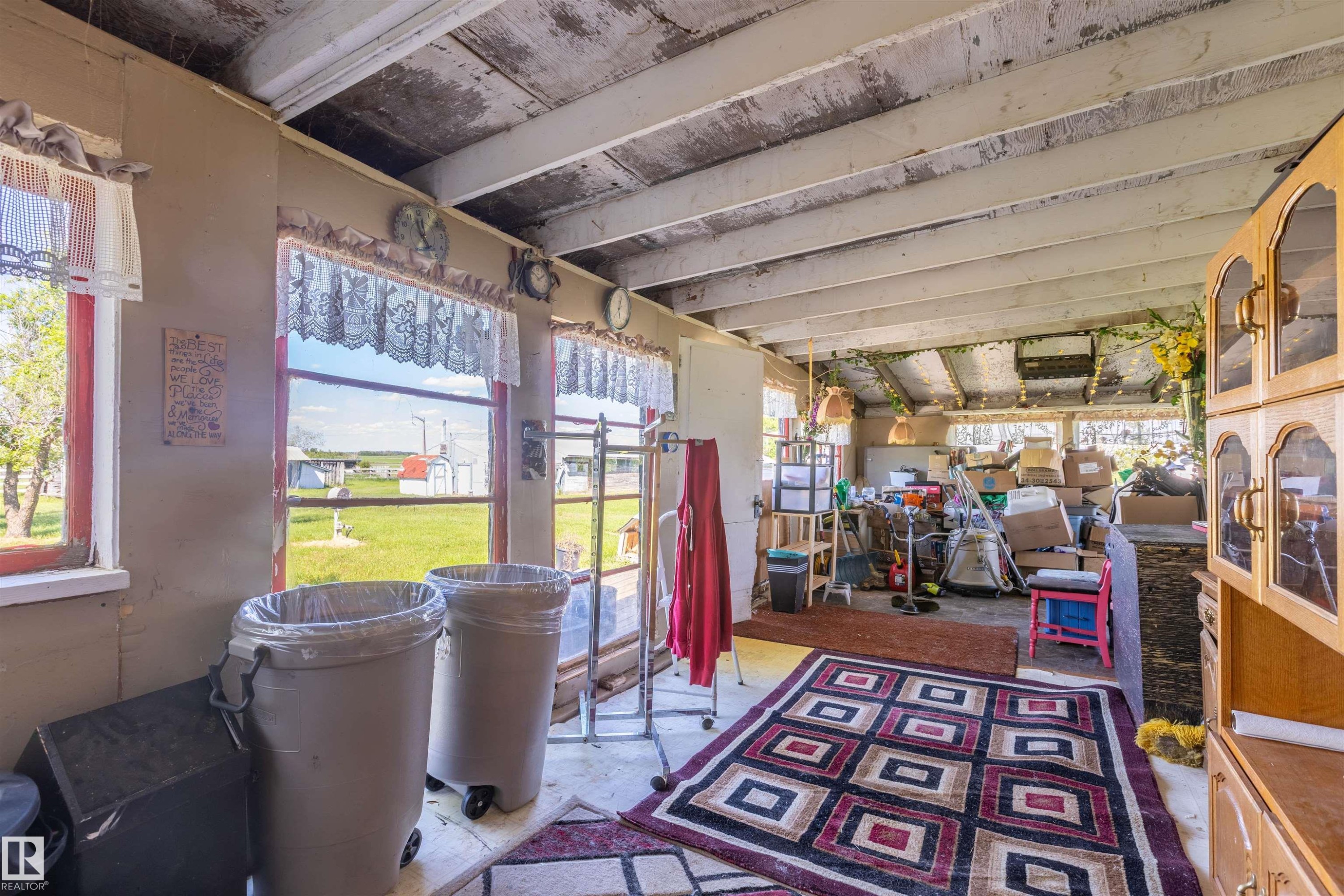 Room featuring multiple windows, exposed ceiling beams, and a built-in cabinetry unit - 551027 Range Road 193, Rural Lamont County, AB