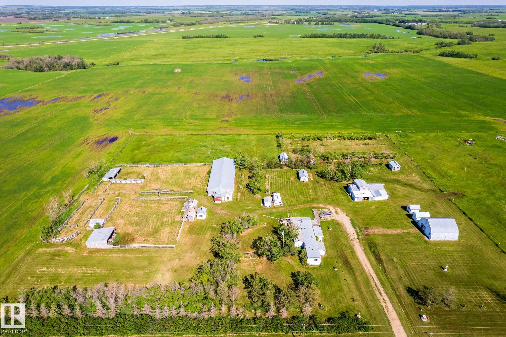 Expansive agricultural property featuring multiple outbuildings, cultivated fields, and established tree lines - 551027 Range Road 193, Rural Lamont County, AB