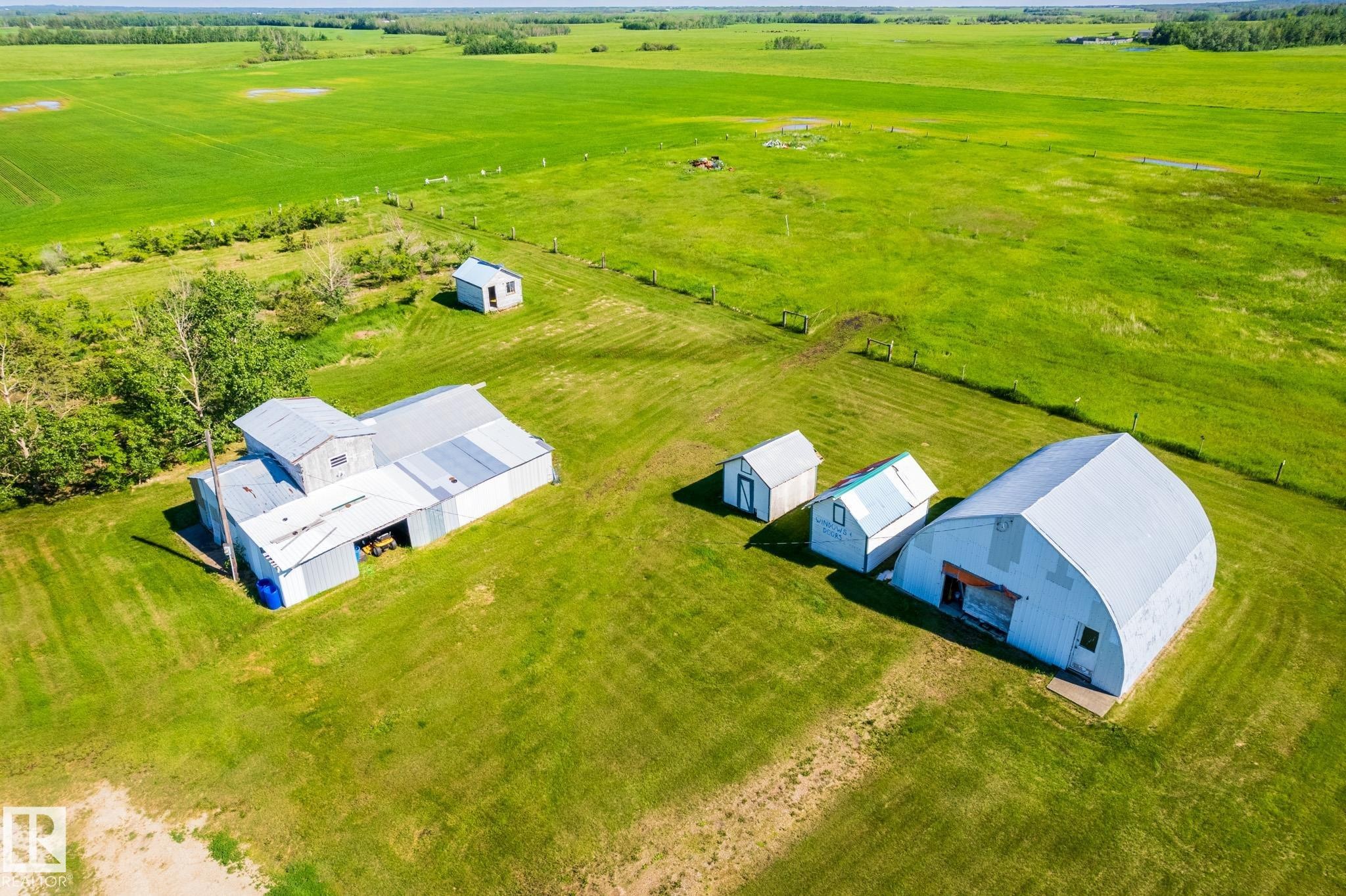 Expansive green acreage featuring multiple outbuildings, including a large Quonset-style structure - 551027 Range Road 193, Rural Lamont County, AB