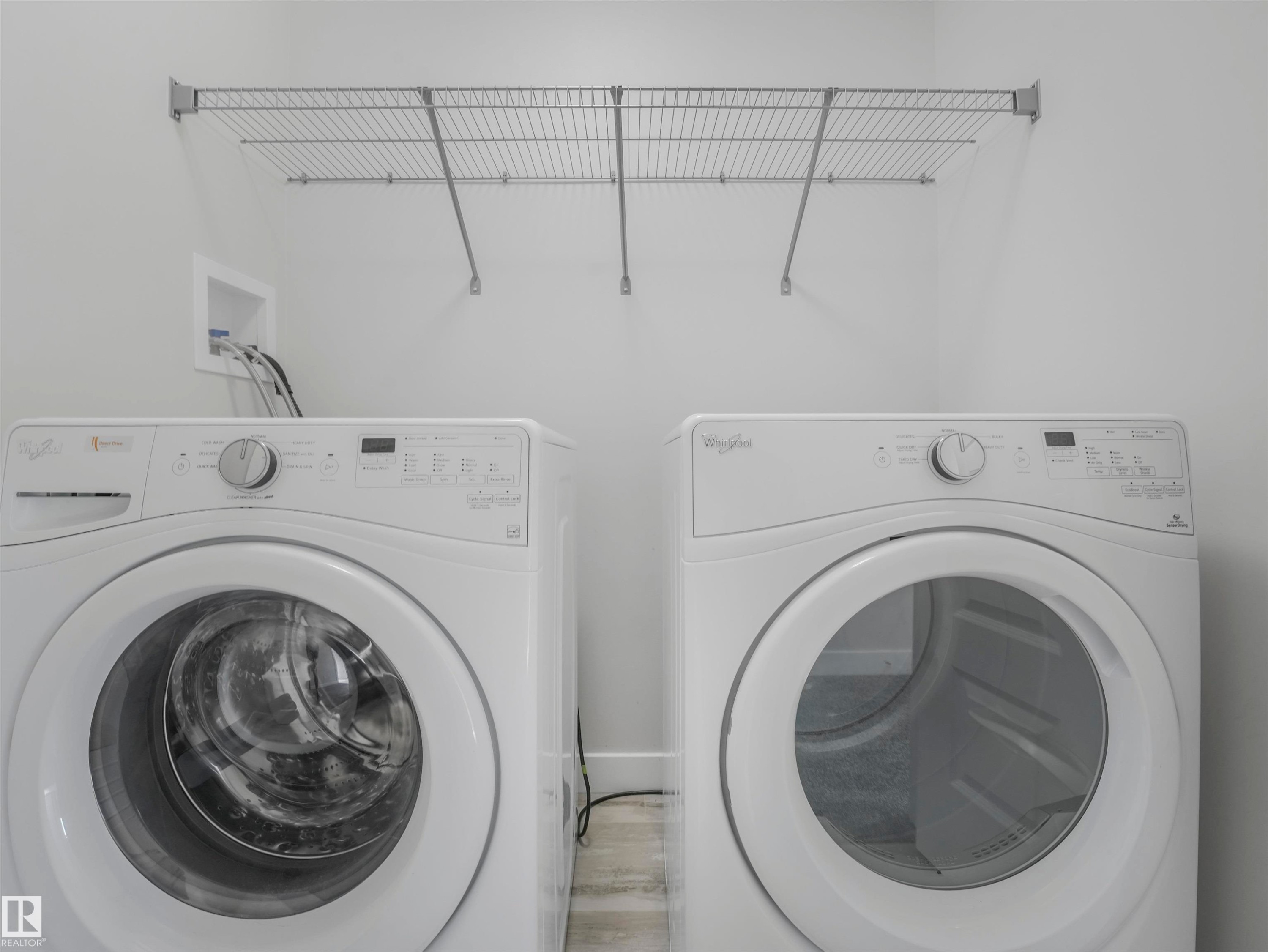 Laundry area with a wall-mounted wire shelving unit and light-toned flooring - 20507 99 Avenue, Edmonton, AB - Indoor Photo Showing Laundry Room