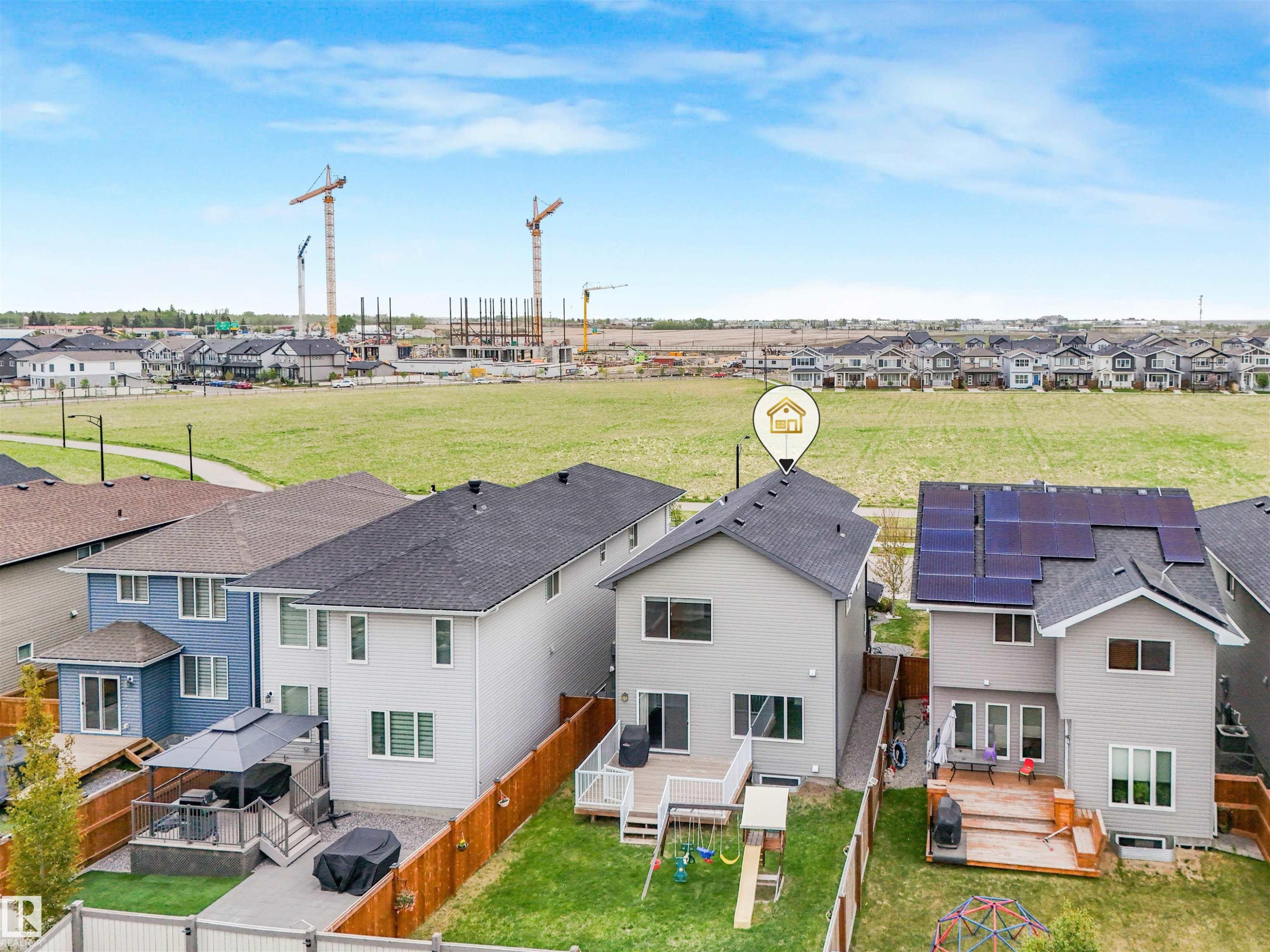 Rear exterior featuring a two-story design with light gray siding, a dark shingle roof, and multiple windows - 20507 99 Avenue, Edmonton, AB - Outdoor
