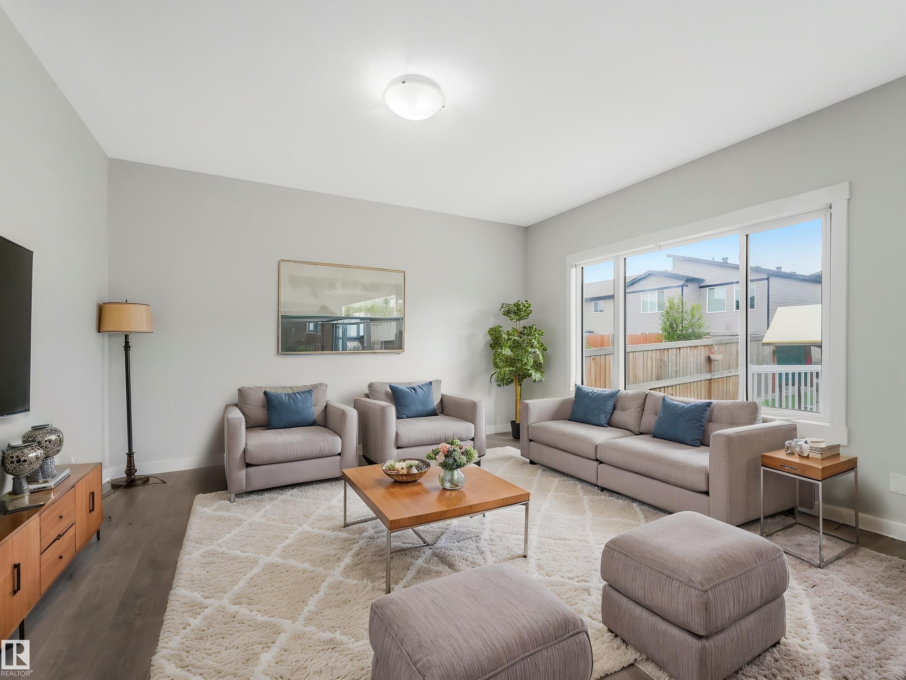 Spacious interior featuring wood-finish flooring, light gray wall tones, and a large window providing ample natural light - 20507 99 Avenue, Edmonton, AB - Indoor Photo Showing Living Room
