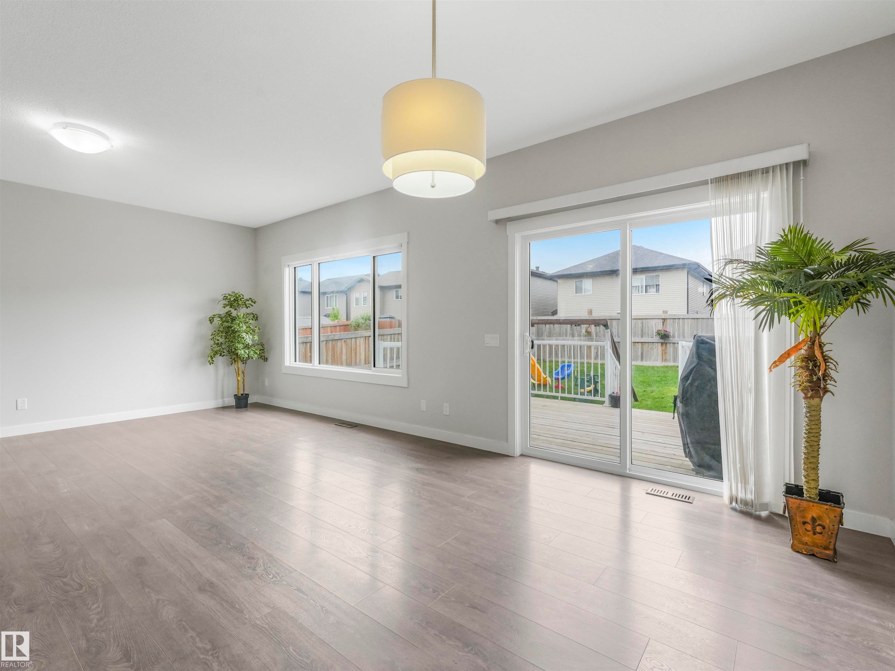 Spacious interior featuring wood-finish flooring, light grey wall paint, and recessed lighting - 20507 99 Avenue, Edmonton, AB - Indoor Photo Showing Other Room