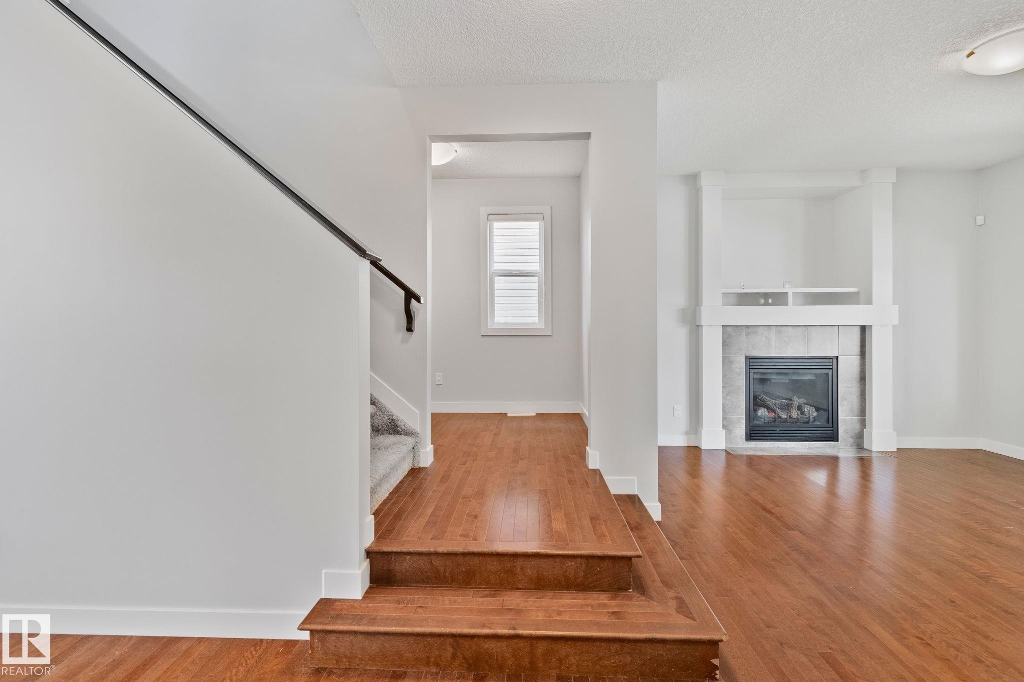 Warm wood-finish flooring throughout the main level - 614 Mcdonough Link, Edmonton, AB