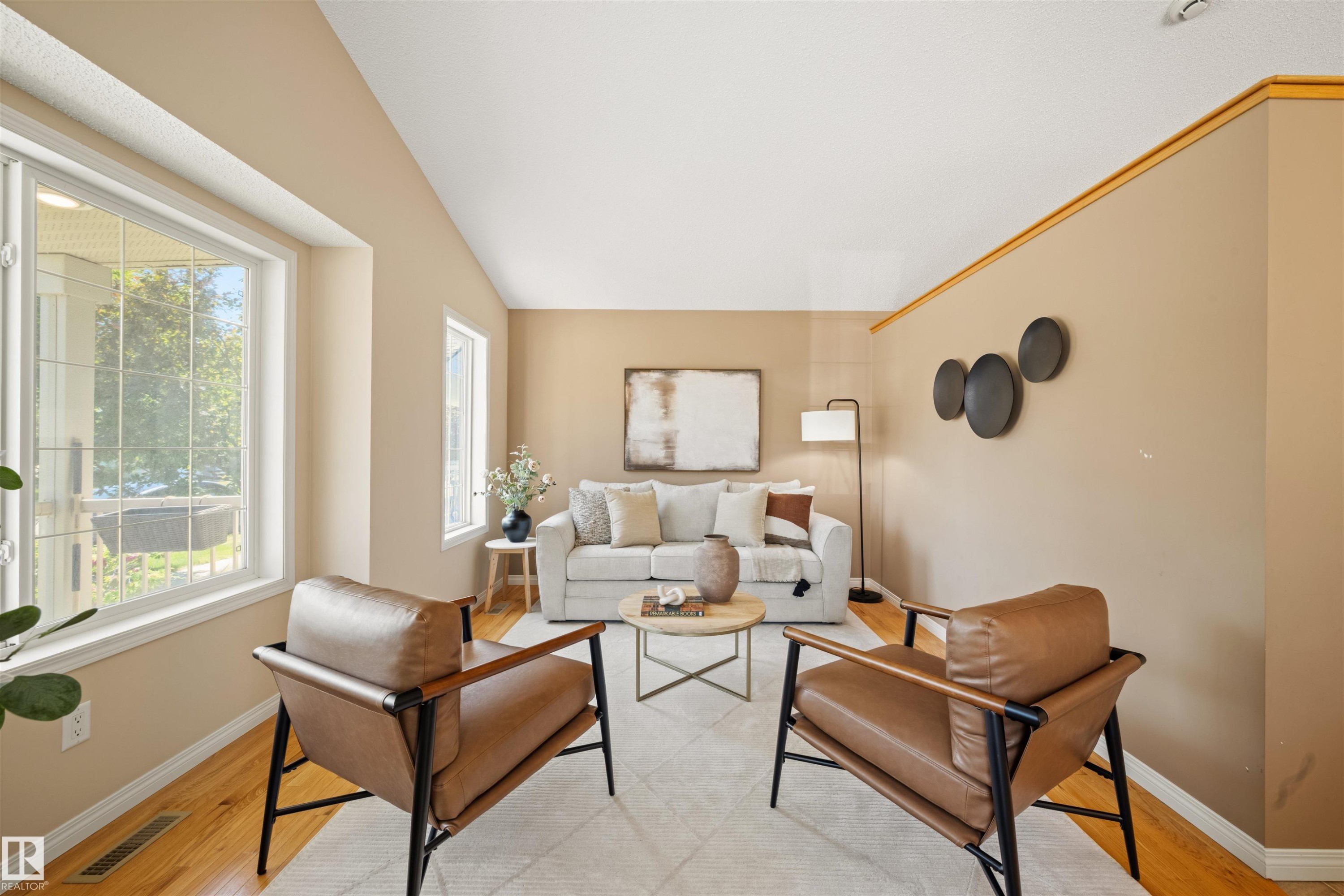 Living area featuring warm neutral wall tones and wood-finish flooring - 7838 Schmid Place Nw, Edmonton, AB - Indoor Photo Showing Living Room