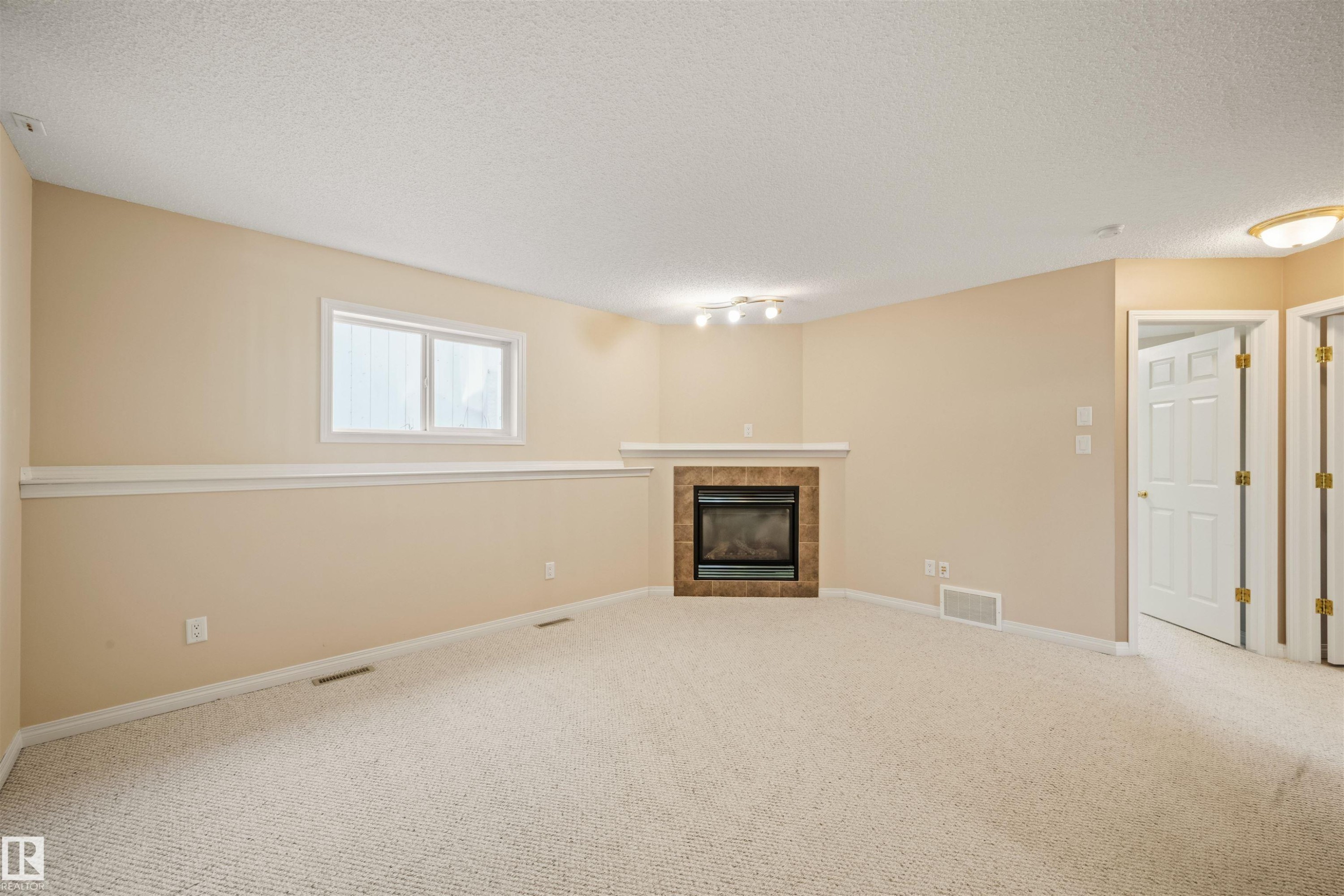 Recessed fireplace with tile surround and mantel - 7838 Schmid Place Nw, Edmonton, AB - Indoor With Fireplace