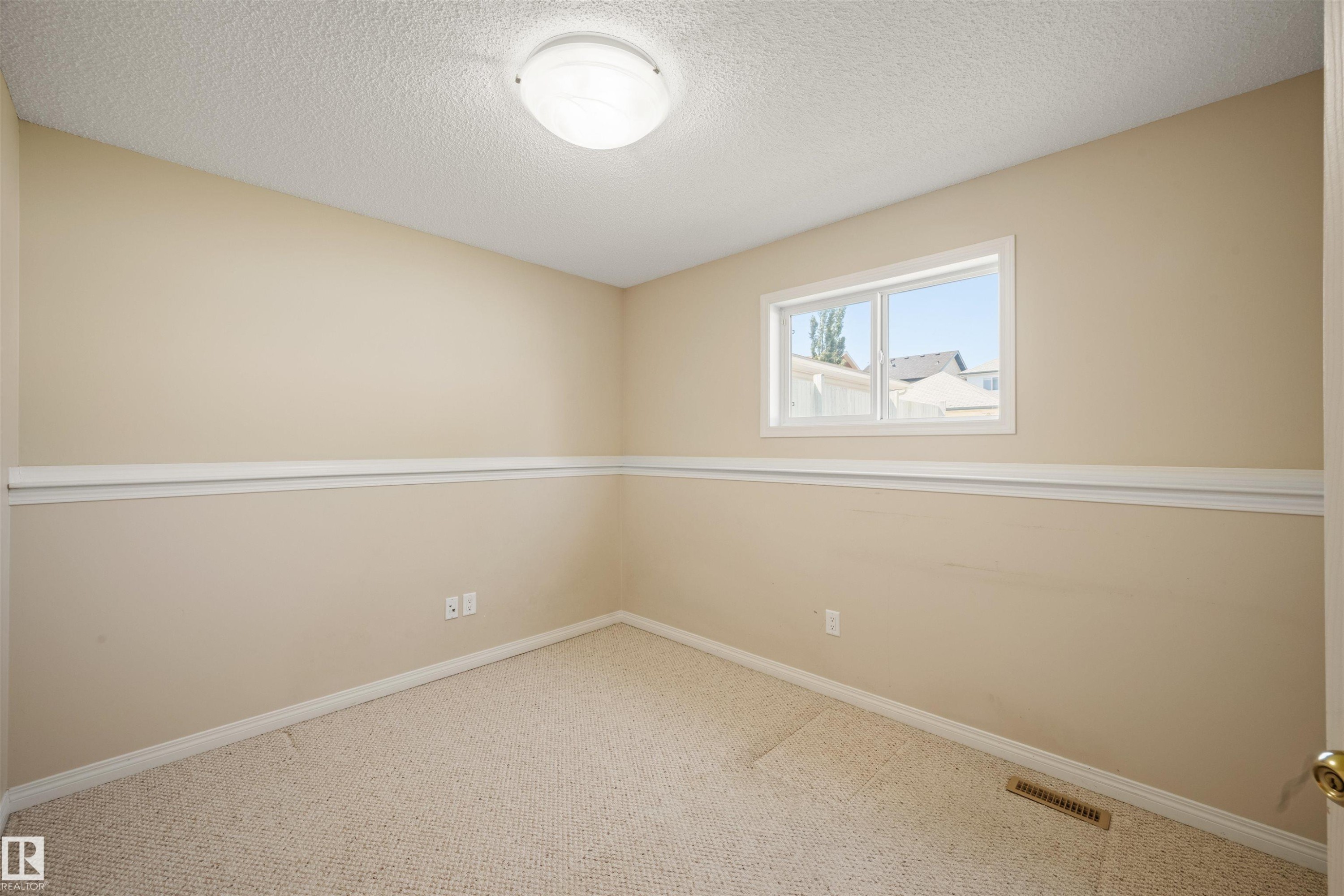Neutral-toned carpeting paired with beige walls and white trim - 7838 Schmid Place Nw, Edmonton, AB - Indoor Photo Showing Other Room