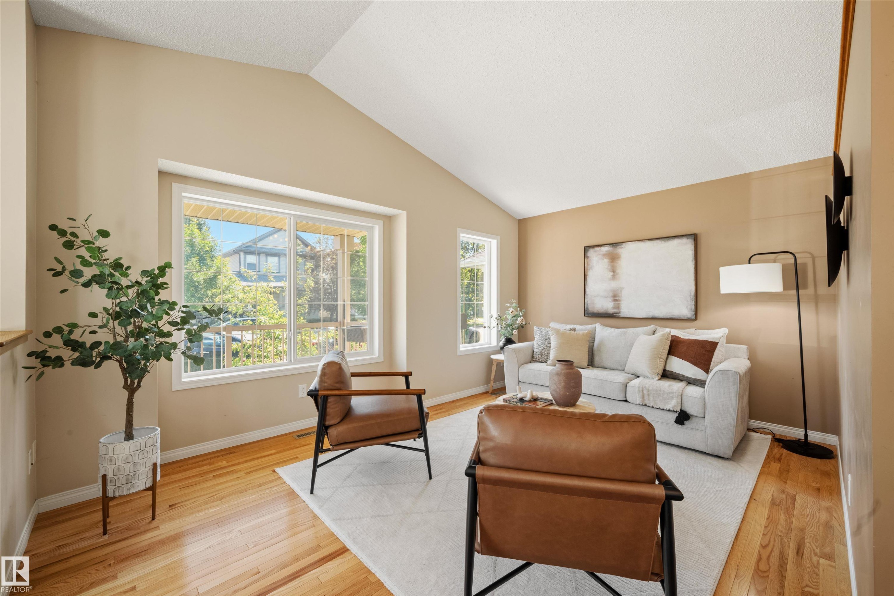 Living area featuring vaulted ceilings, light wood-finish flooring, and a large picture window - 7838 Schmid Place Nw, Edmonton, AB - Indoor Photo Showing Living Room