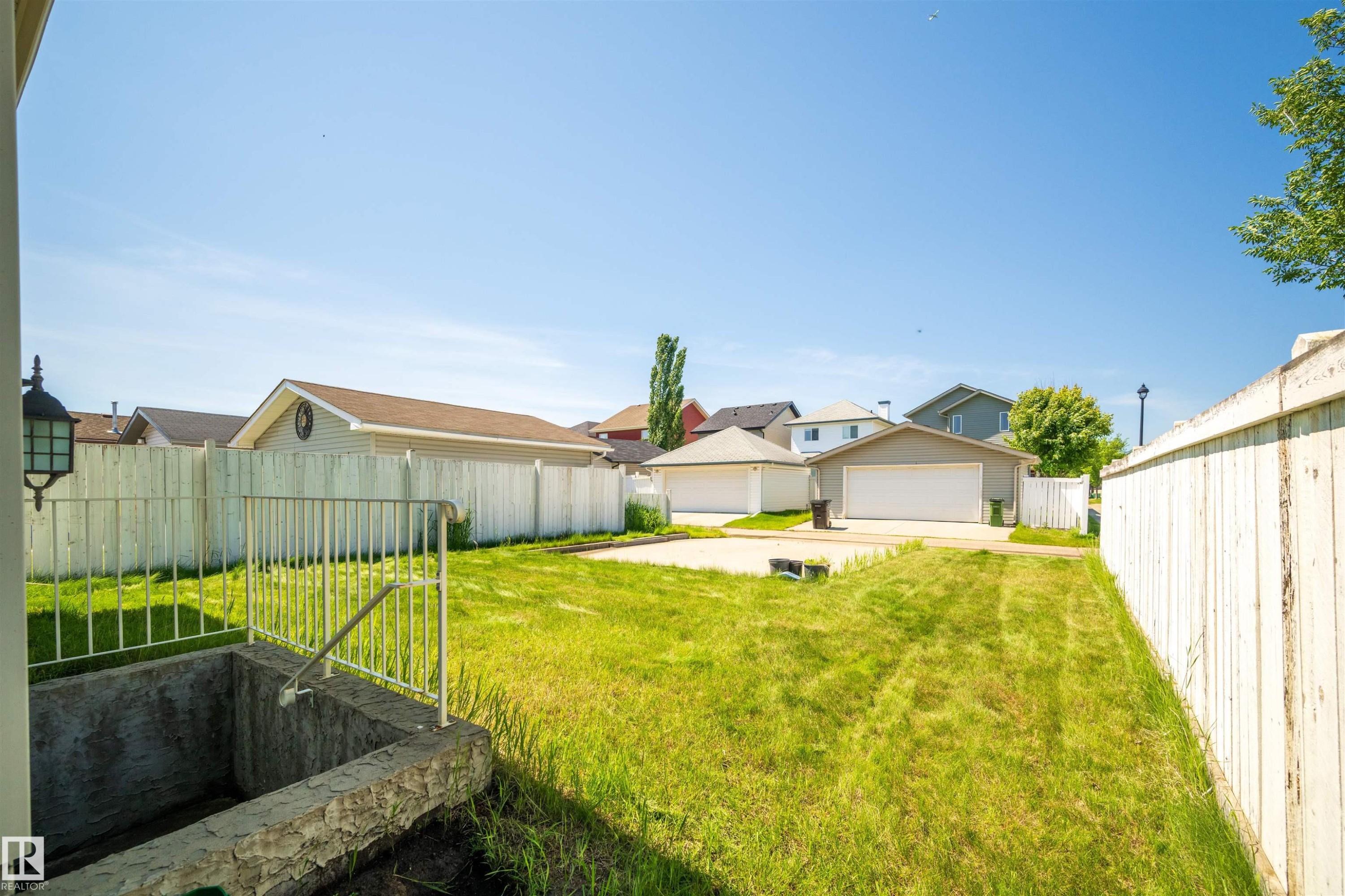 Expansive backyard featuring a mature perimeter fence and a substantial concrete patio pad - 7838 Schmid Place Nw, Edmonton, AB - Outdoor