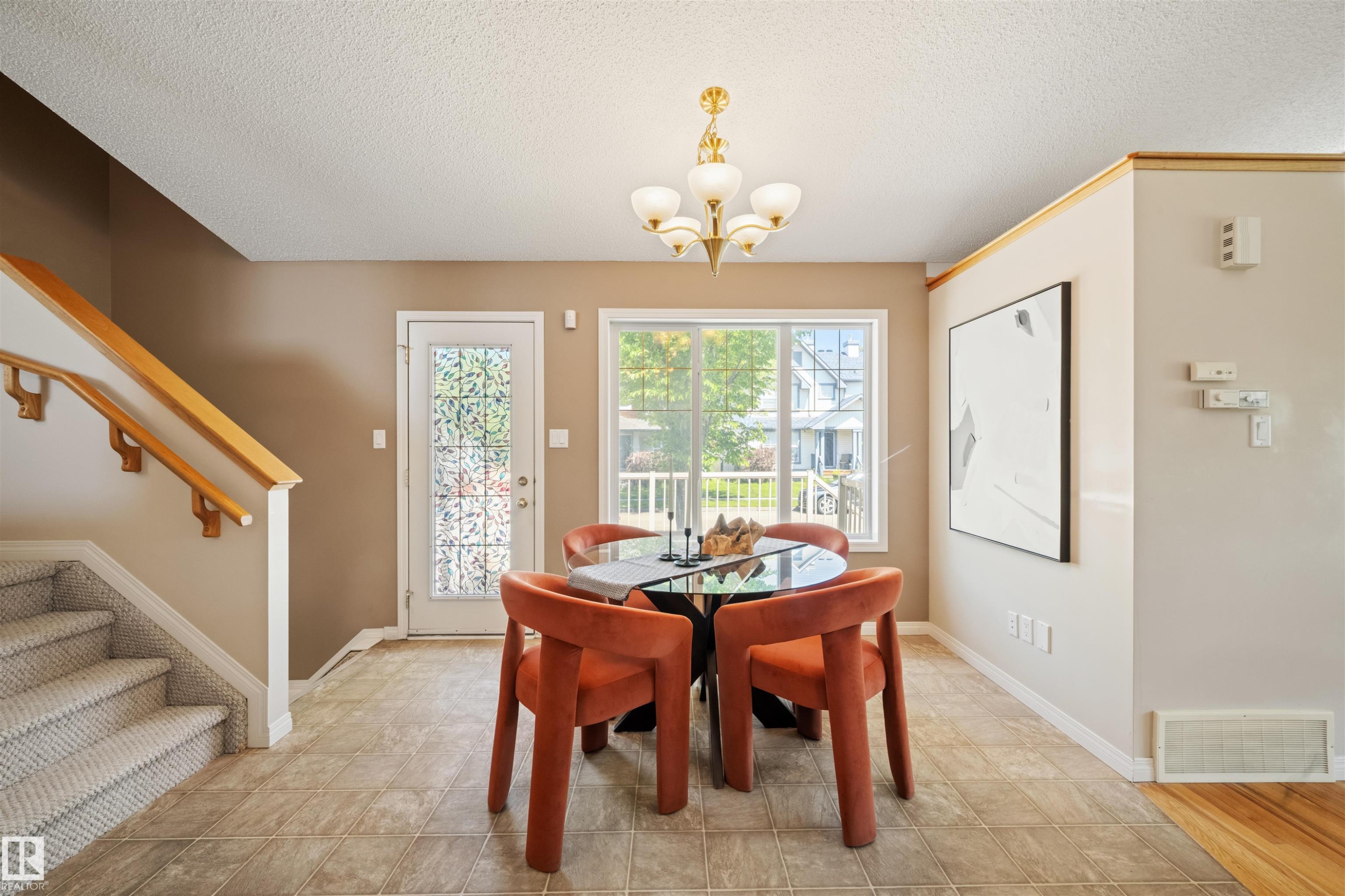 Tiled flooring extending through the dining area with a multi-pane window and glass-paned door - 7838 Schmid Place Nw, Edmonton, AB - Indoor