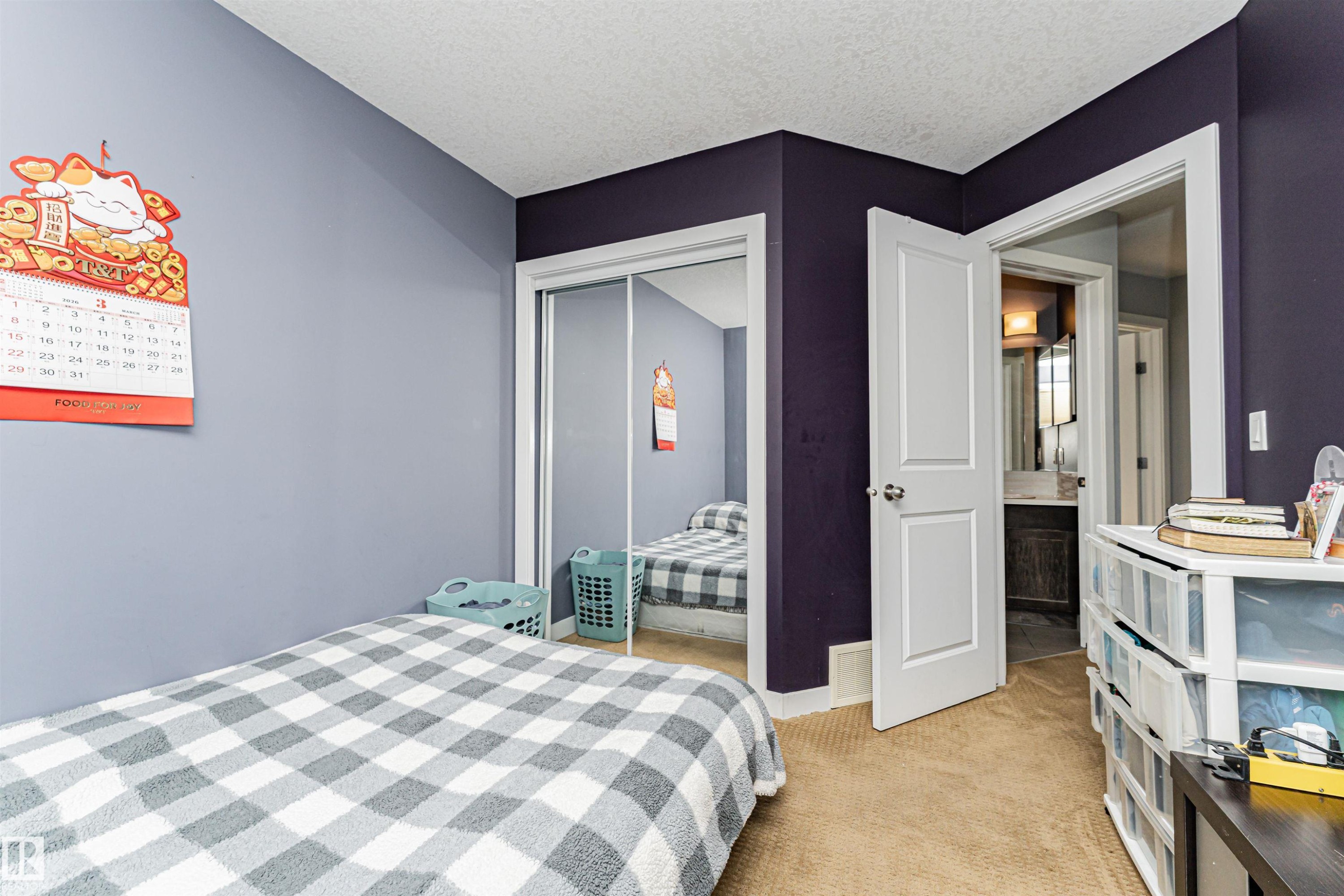 Carpeted room featuring a mirrored closet, white trim, and a white interior door - 35 675 Albany Way, Edmonton, AB