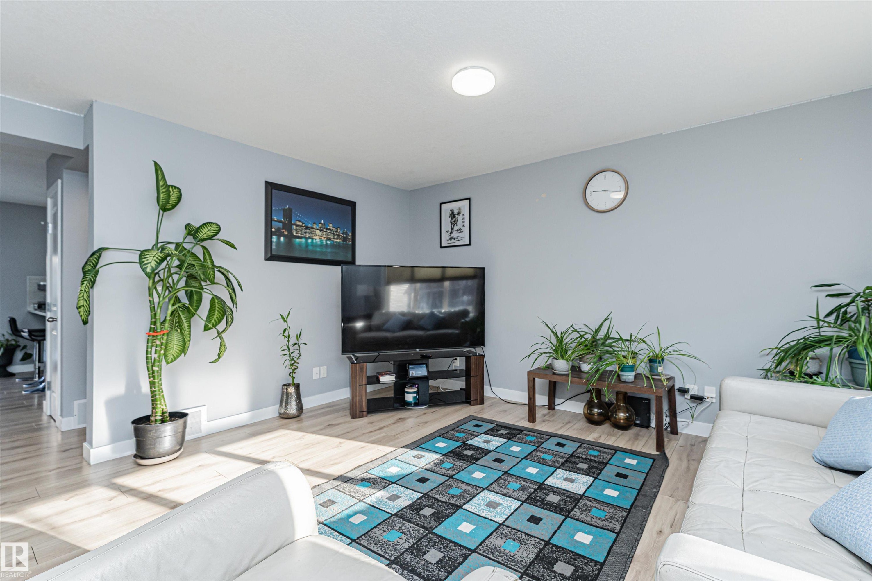 Living area featuring light wood-finish flooring and a neutral wall color - 35 675 Albany Way, Edmonton, AB