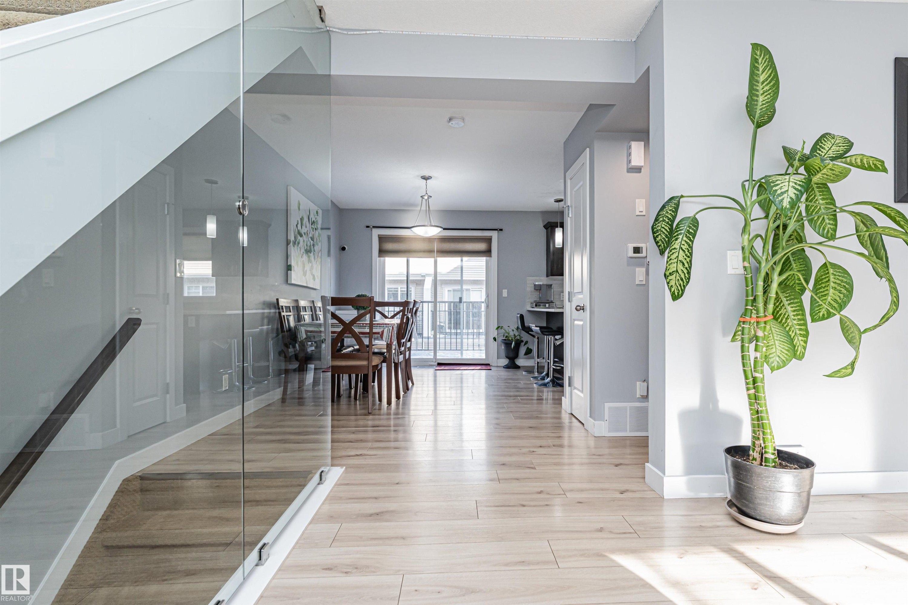 Light wood-finish flooring extending throughout the main level - 35 675 Albany Way, Edmonton, AB
