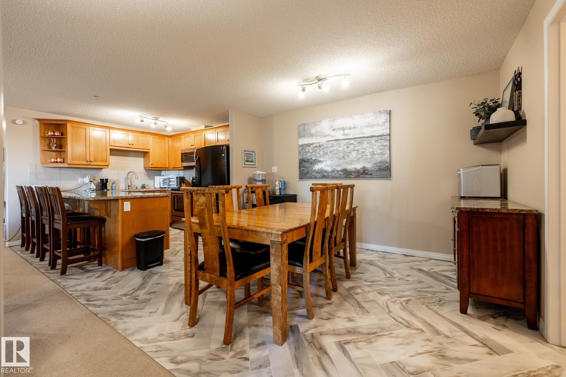 Open-concept kitchen and dining area with wood-finish cabinetry - 330 1520 Hammond Gate Gate, Edmonton, AB