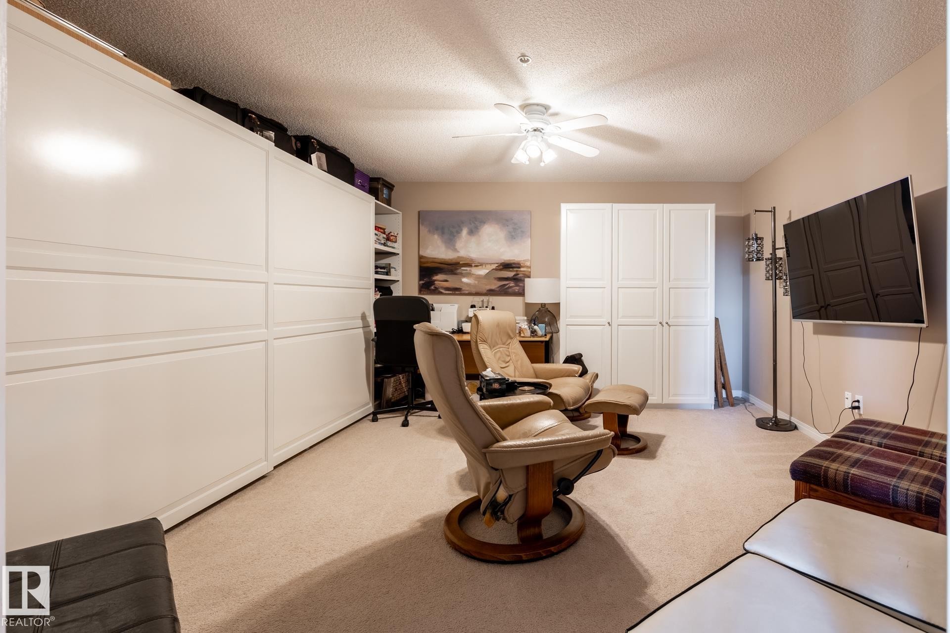 Neutral tone wall color, ceiling fan, textured ceiling, light-toned carpet, and integrated storage cabinetry - 330 1520 Hammond Gate Gate, Edmonton, AB