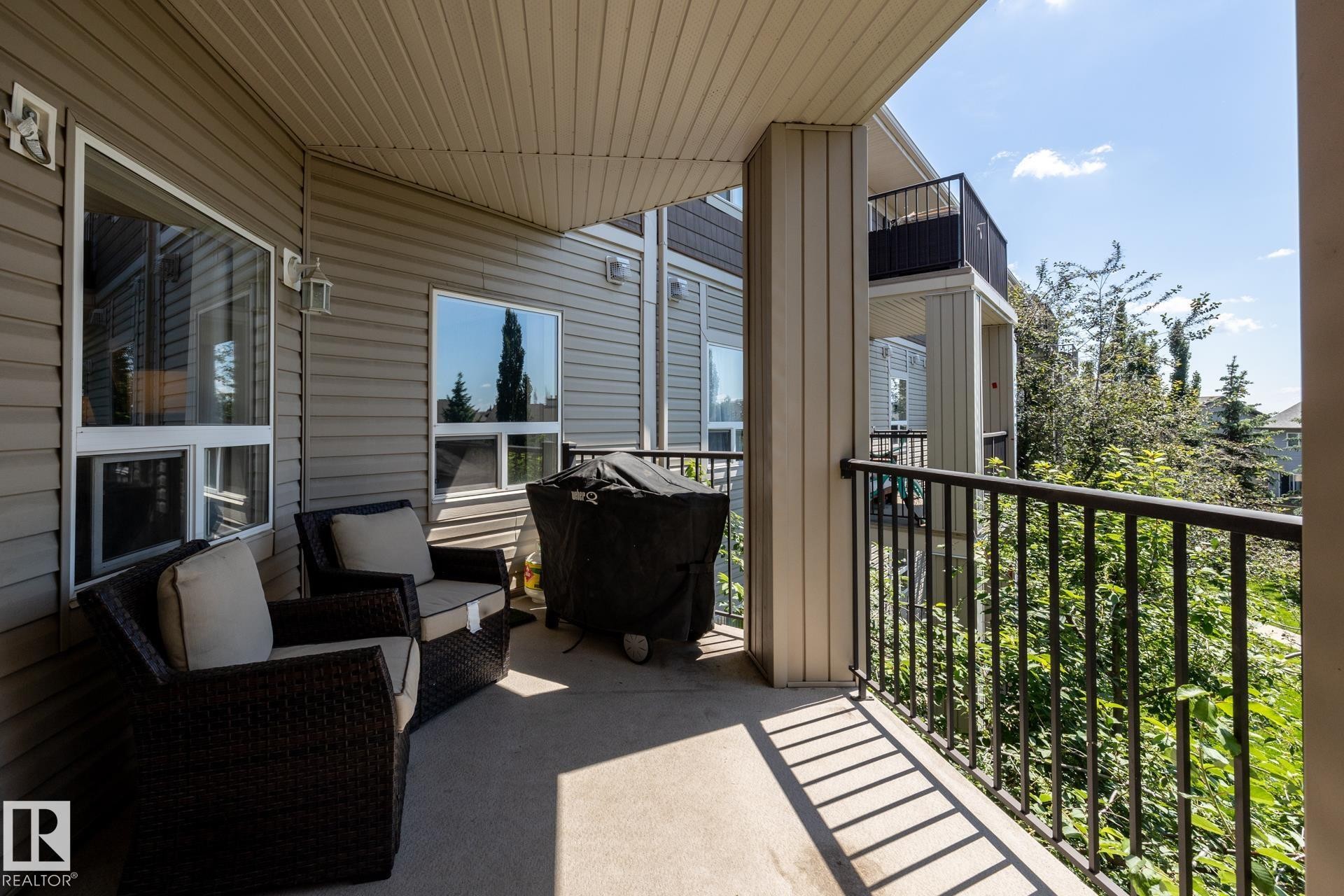 Covered private balcony with a concrete floor and black metal railing - 330 1520 Hammond Gate Gate, Edmonton, AB