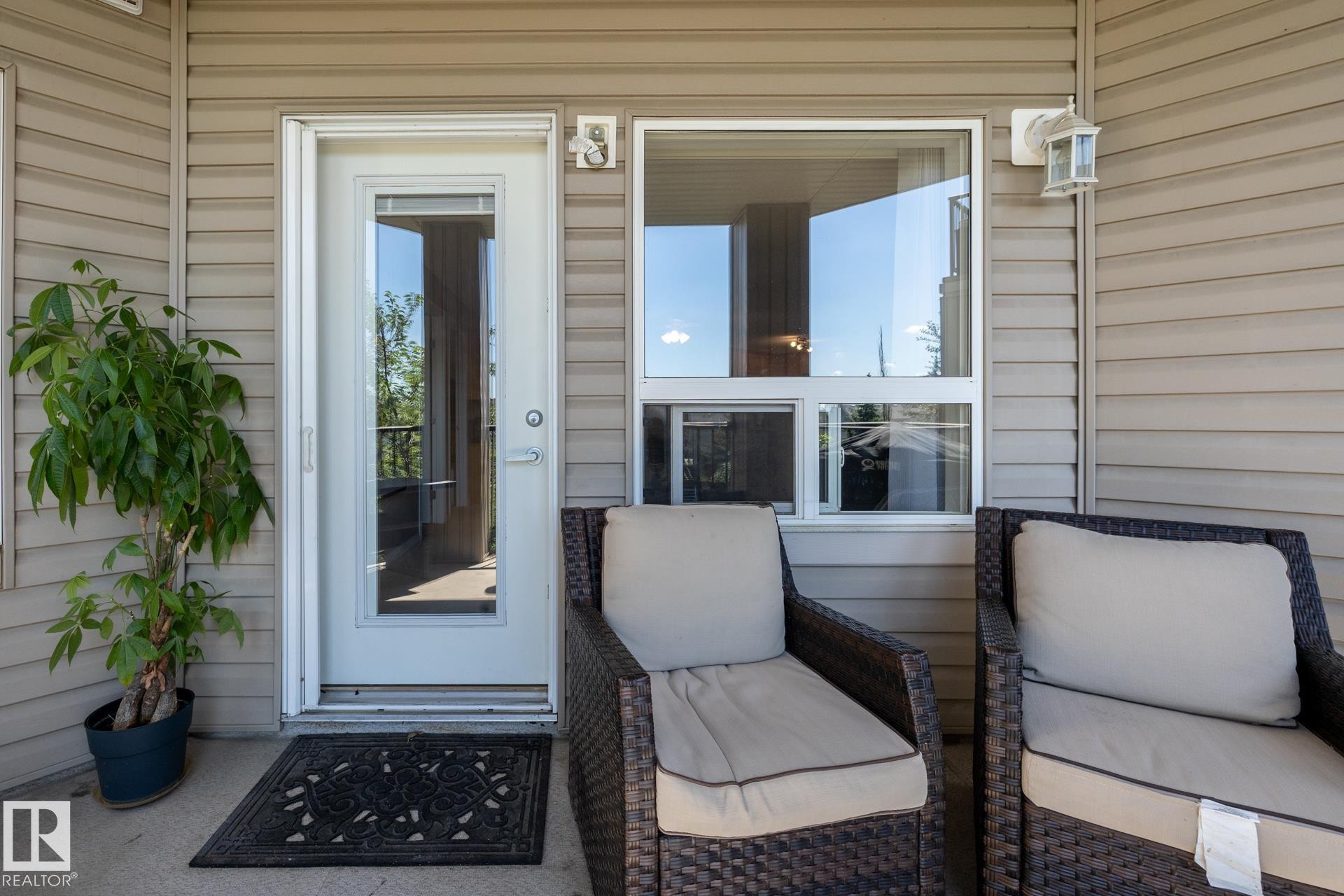 Outdoor patio area featuring neutral-toned horizontal siding - 330 1520 Hammond Gate Gate, Edmonton, AB