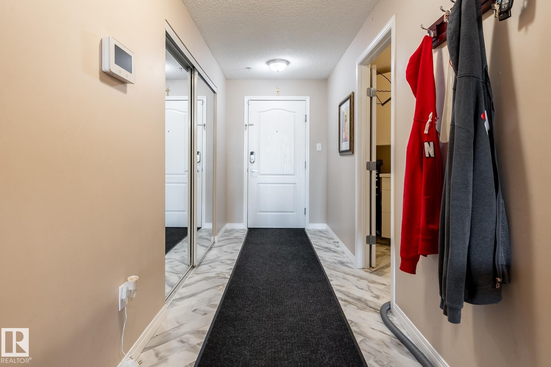 Entryway featuring marble-look flooring, a flush-mount ceiling light, and a built-in thermostat - 330 1520 Hammond Gate Gate, Edmonton, AB