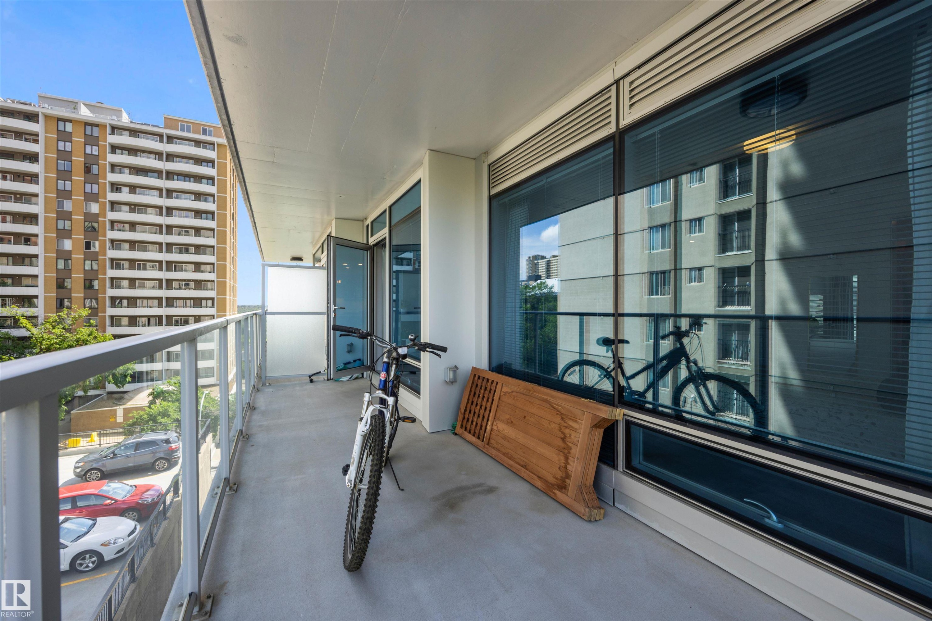 Private balcony with concrete flooring, glass panel railing, and white frame - #802 9720 106 St Nw, Edmonton, AB - Outdoor With Balcony With Exterior