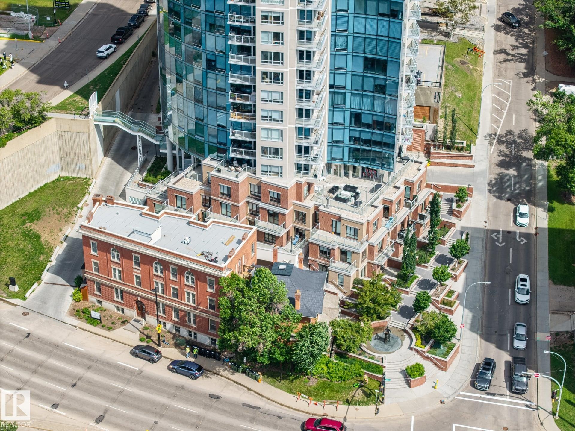 Multi-story building featuring a glass facade and brick lower levels - #802 9720 106 St Nw, Edmonton, AB - Outdoor With Balcony