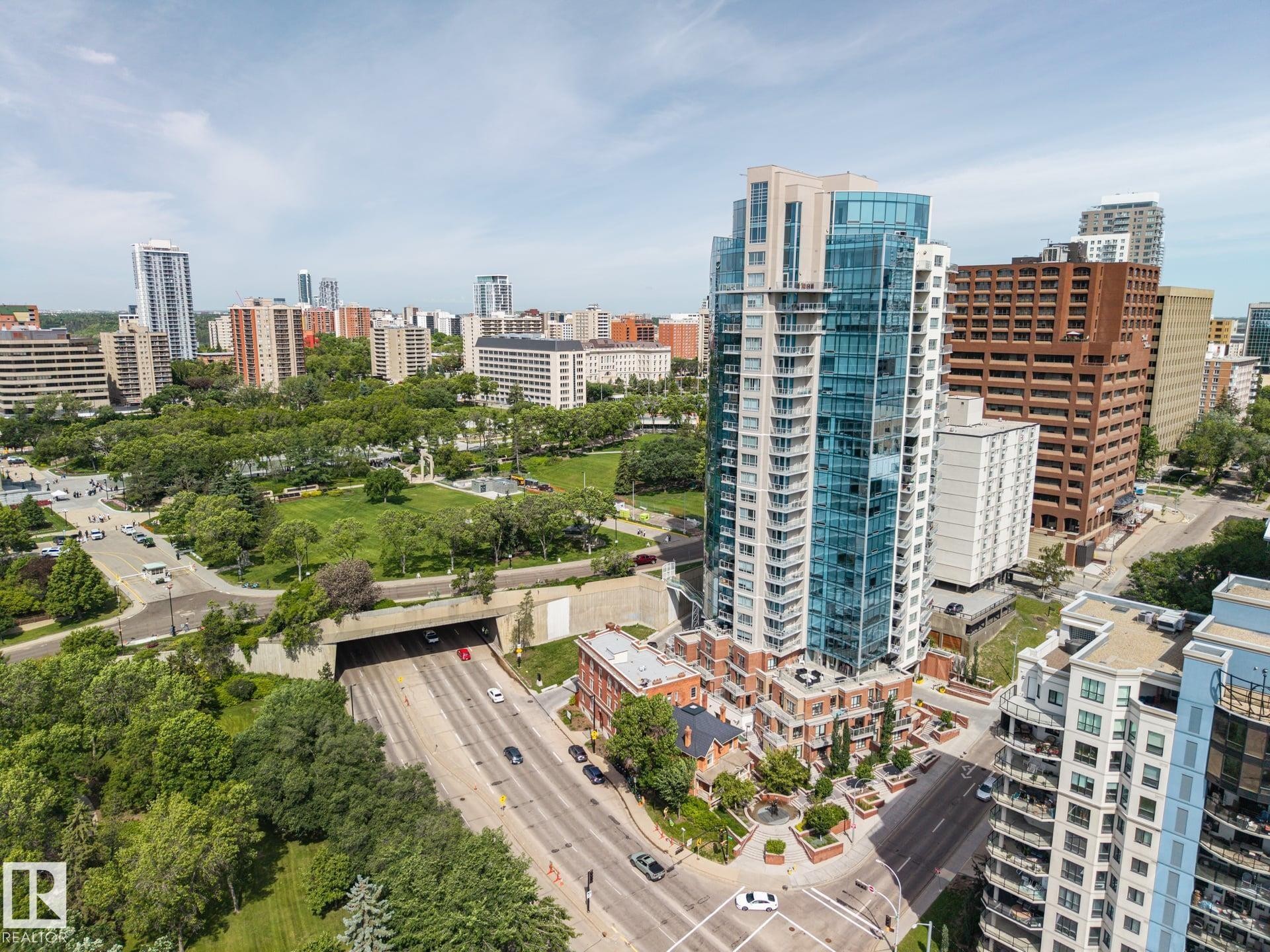 Modern high-rise building with a curved glass facade and multiple balconies - #802 9720 106 St Nw, Edmonton, AB - Outdoor