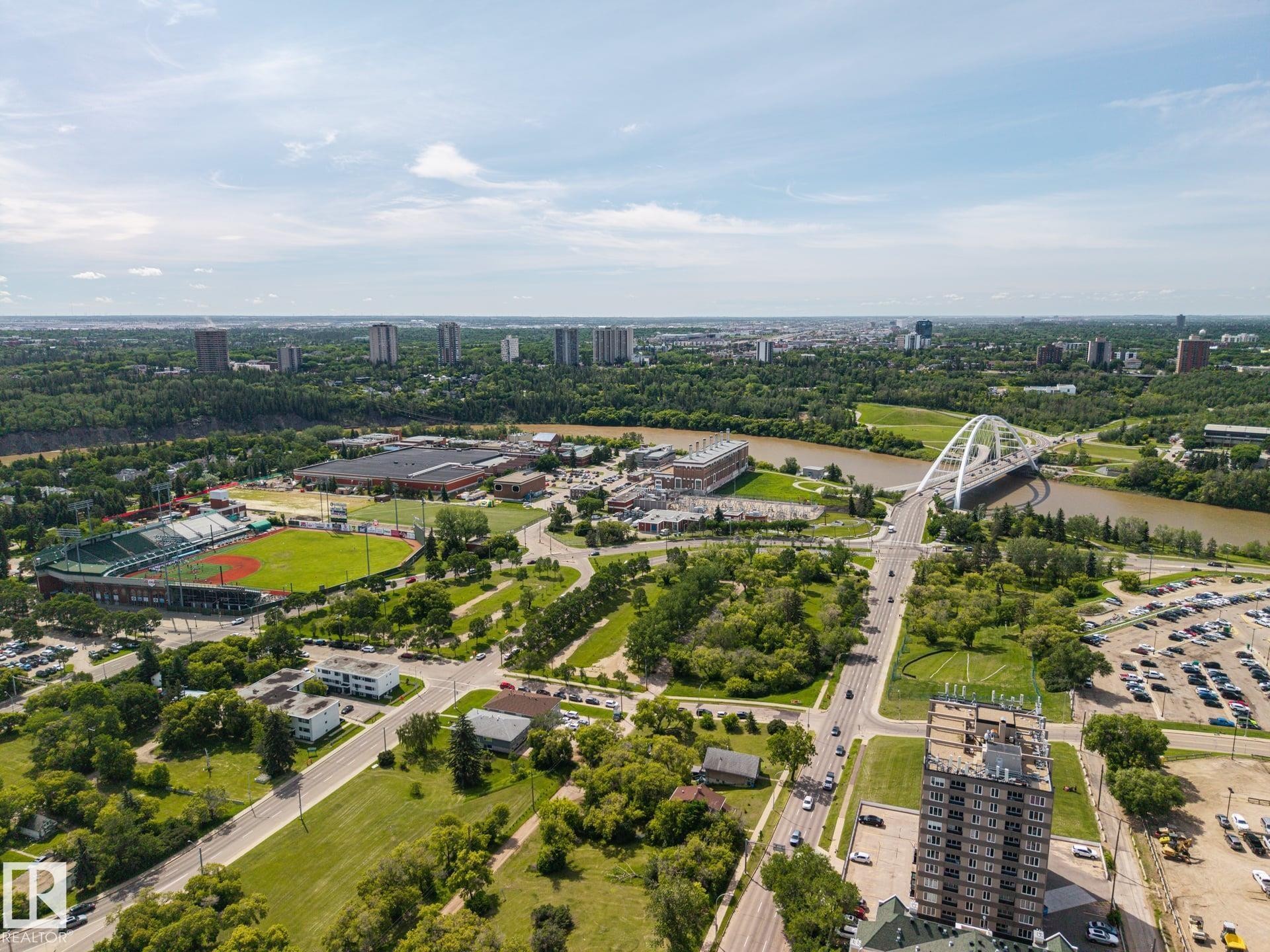 Expansive aerial perspective capturing a city skyline, a river, and a large green baseball stadium - #802 9720 106 St Nw, Edmonton, AB - Outdoor With View