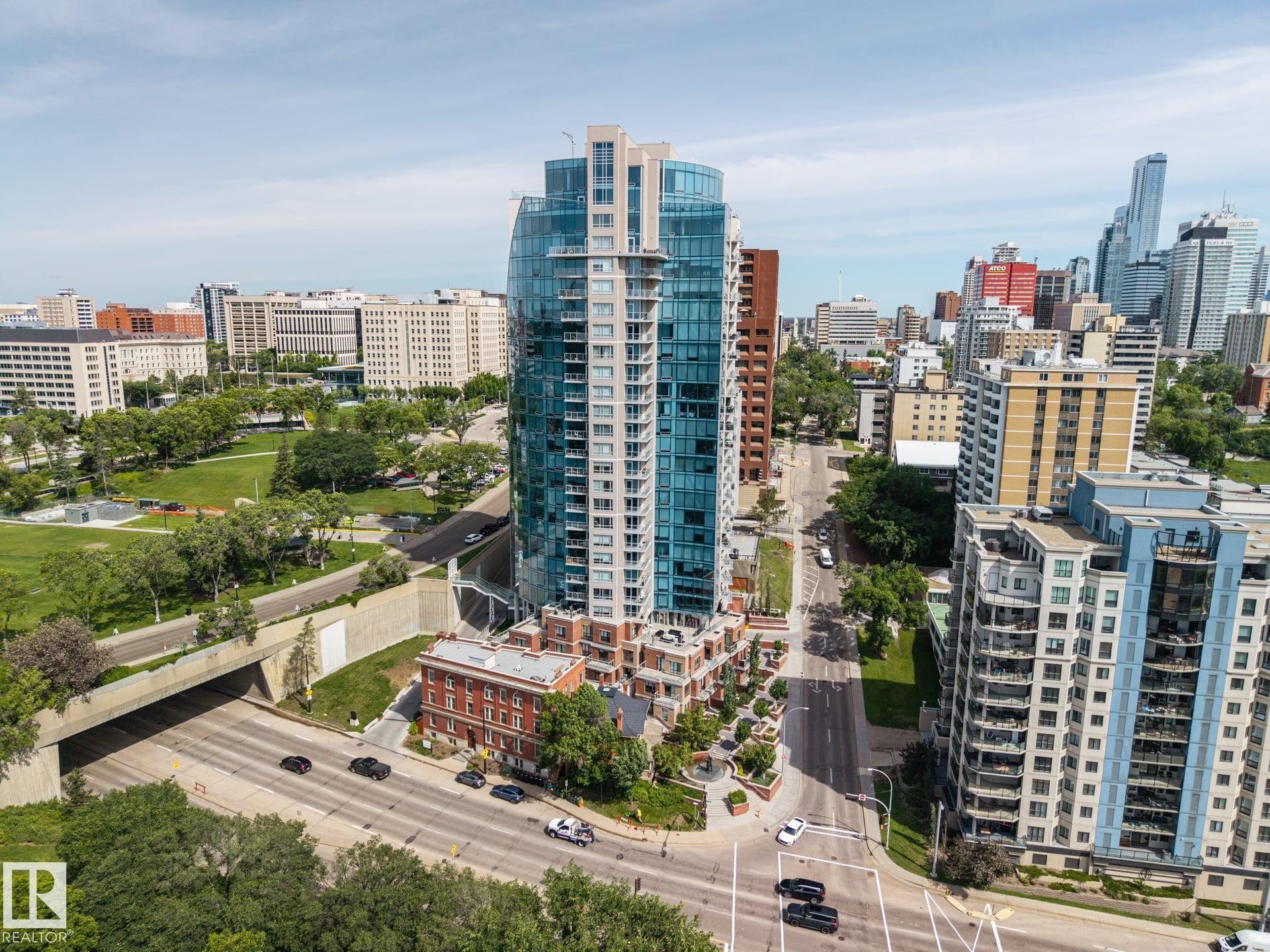 Contemporary high-rise building with a curved glass facade and multiple balconies - #802 9720 106 St Nw, Edmonton, AB - Outdoor With View