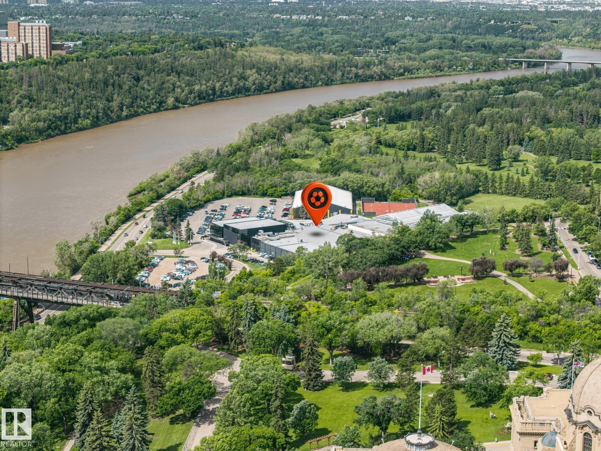 Aerial perspective showcasing the river valley, lush green spaces, extensive tree coverage, and a distant bridge structure - #802 9720 106 St Nw, Edmonton, AB - Outdoor With View
