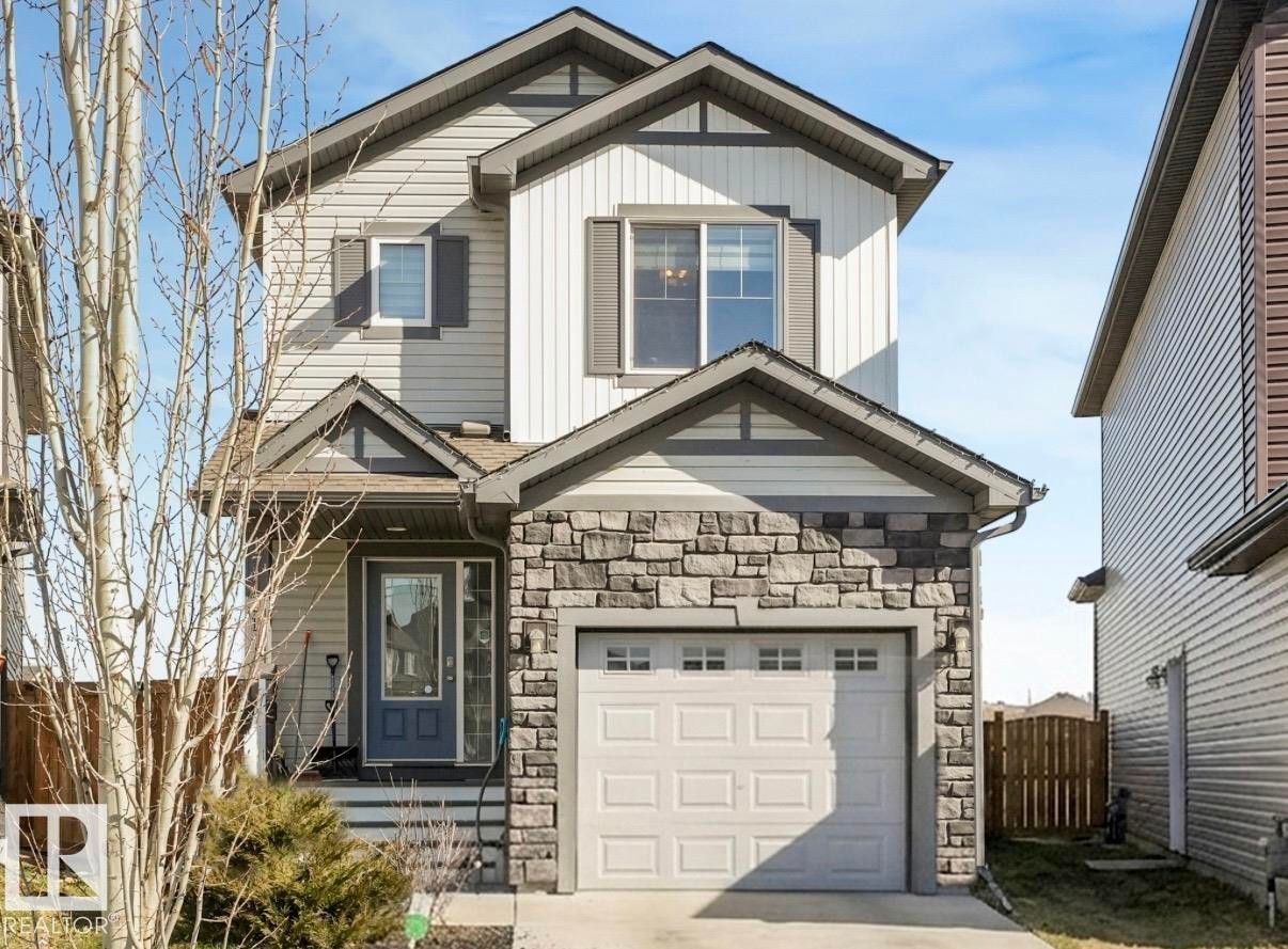Two-story residence featuring a stone facade, a single-car garage, and a covered entryway - 17171 38 Street, Edmonton, AB