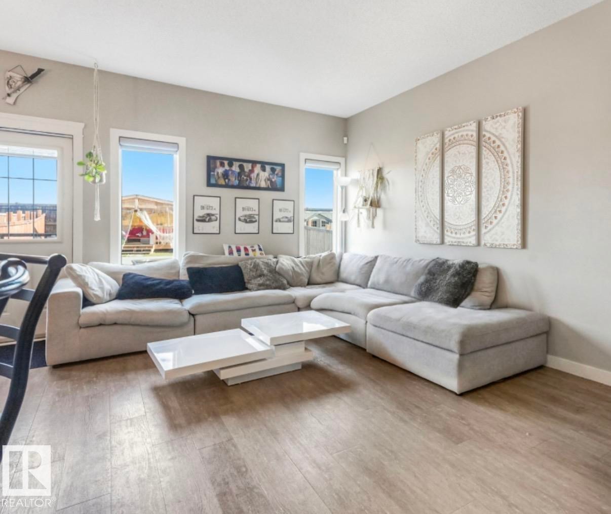 Spacious living area featuring light-toned walls and wood-finish flooring - 17171 38 Street, Edmonton, AB