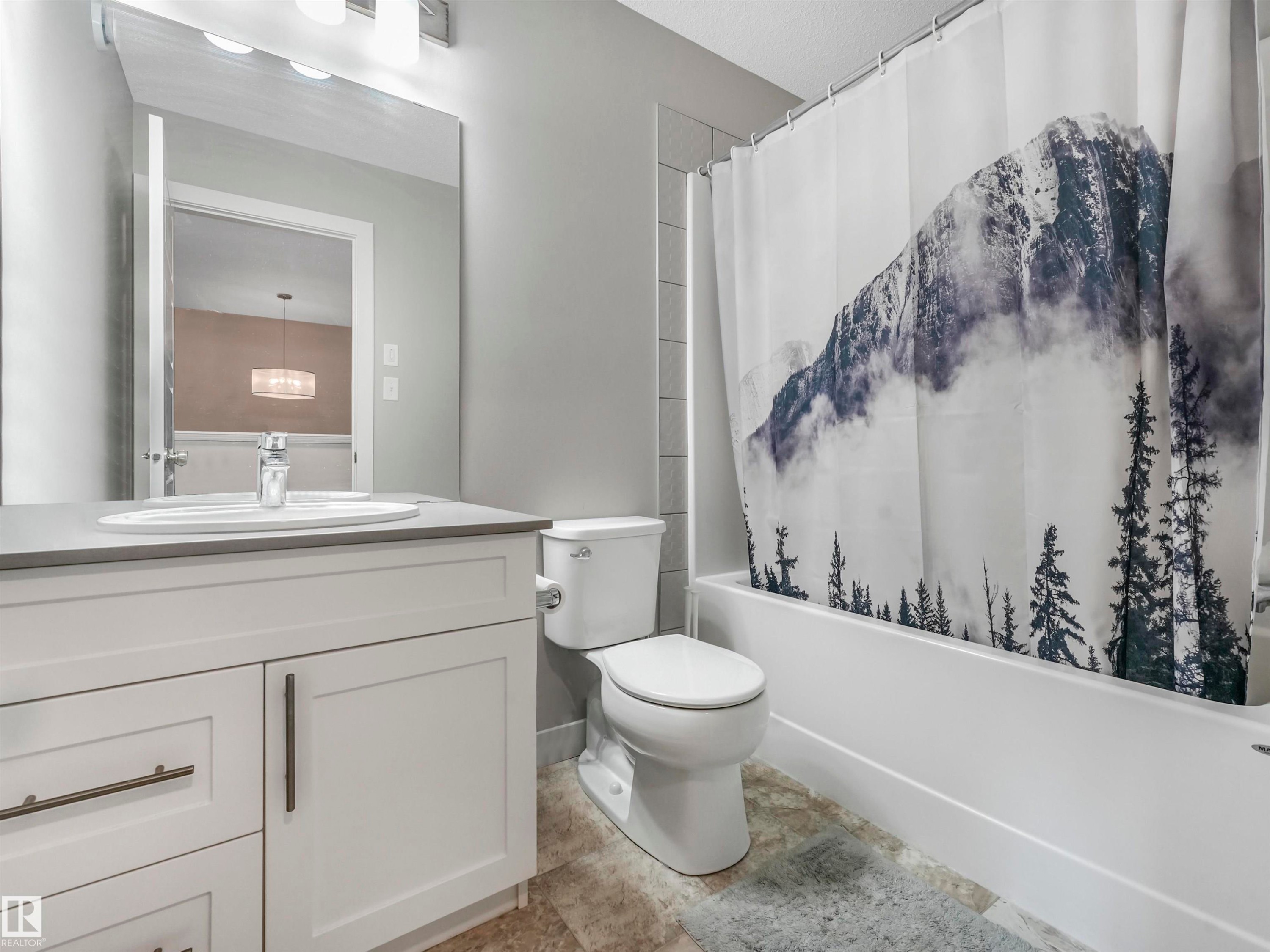Bathroom featuring a white vanity with a gray countertop, an undermount sink, and brushed nickel hardware - 17171 38 Street, Edmonton, AB