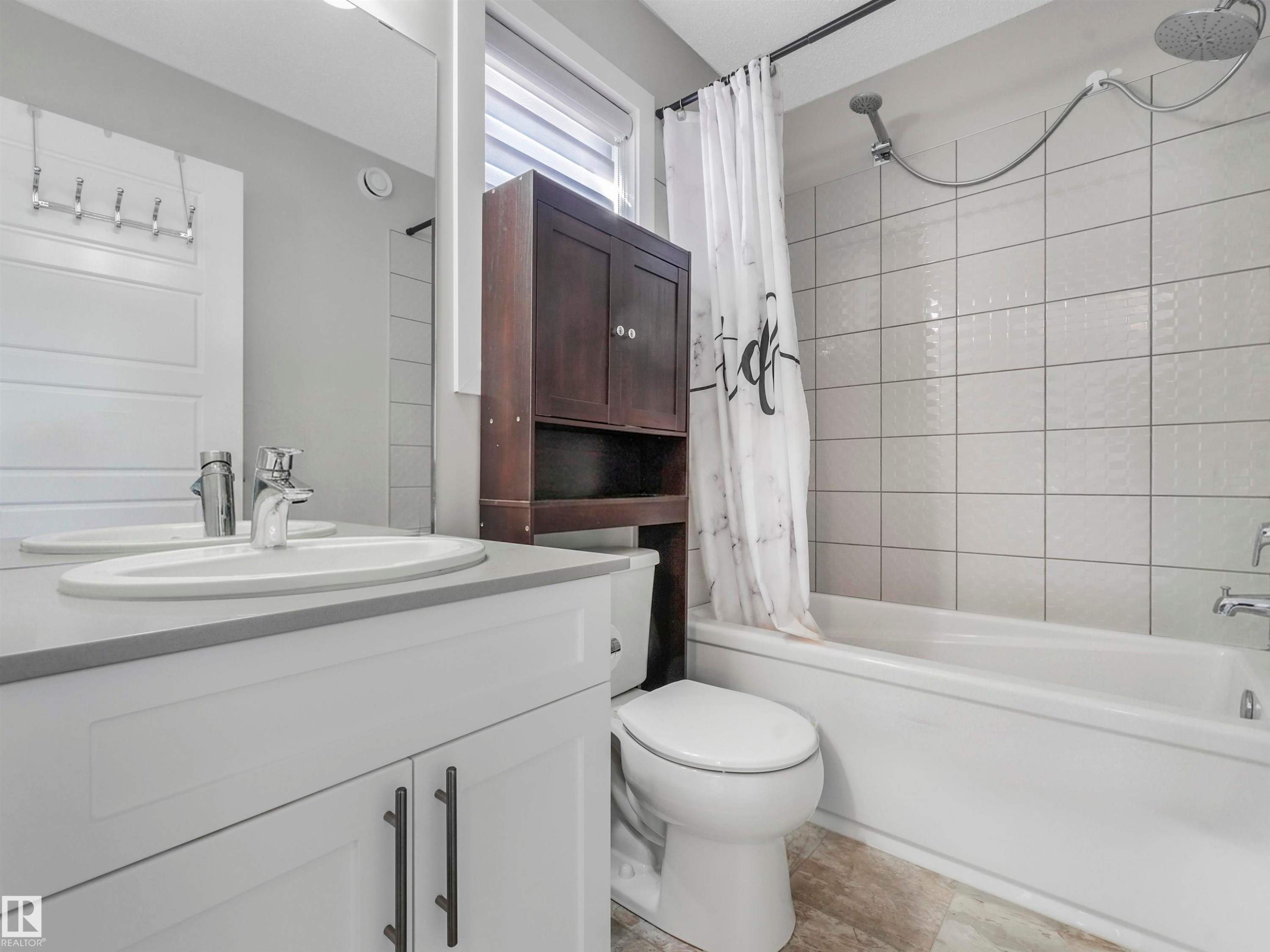 Bathroom featuring a white vanity with a gray countertop, an undermount sink, and chrome fixtures - 17171 38 Street, Edmonton, AB