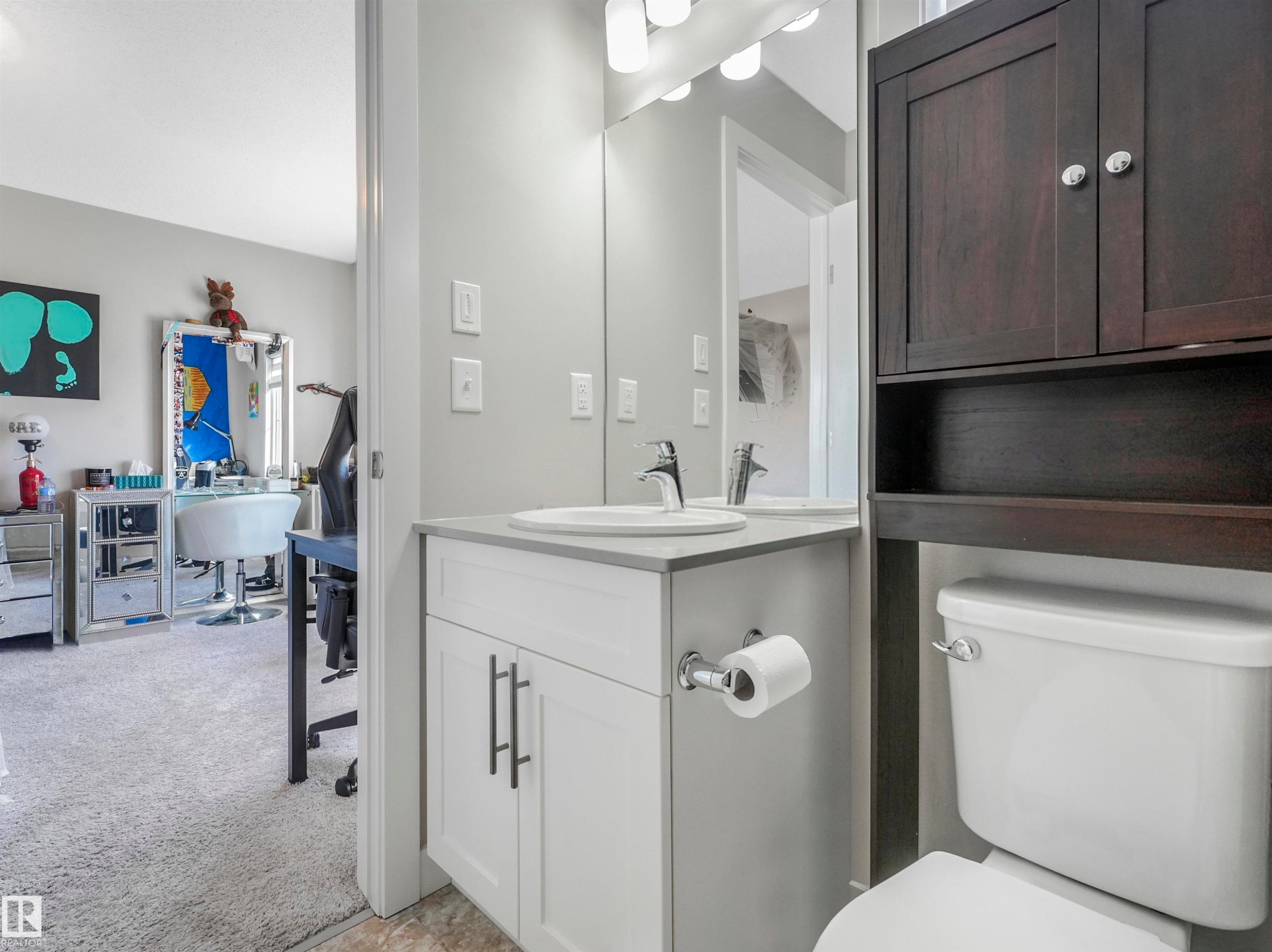 Bathroom featuring a white vanity with a light gray countertop, undermount sink, and chrome faucet - 17171 38 Street, Edmonton, AB