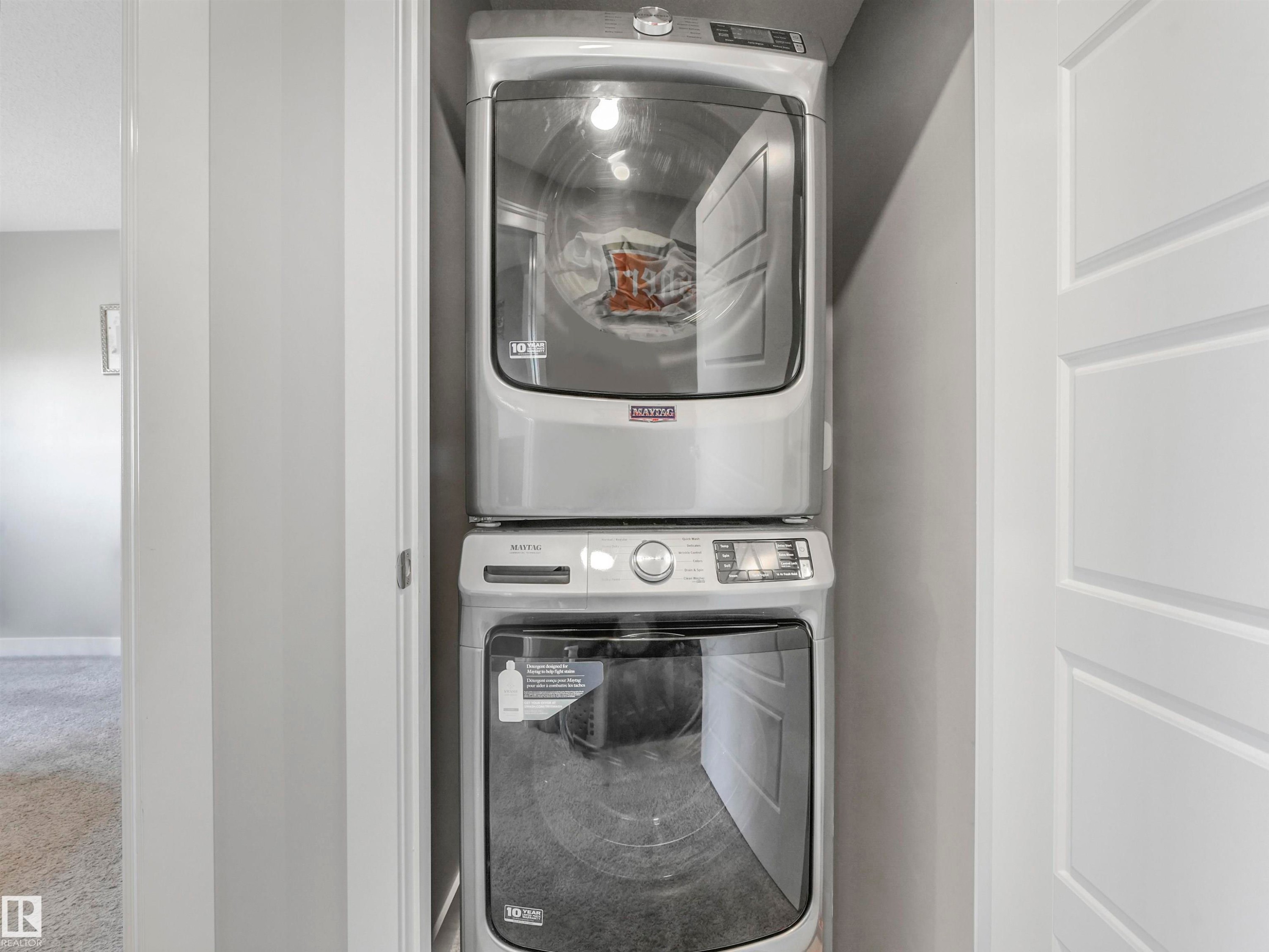 Compact laundry closet featuring a stacked washer and dryer unit - 17171 38 Street, Edmonton, AB