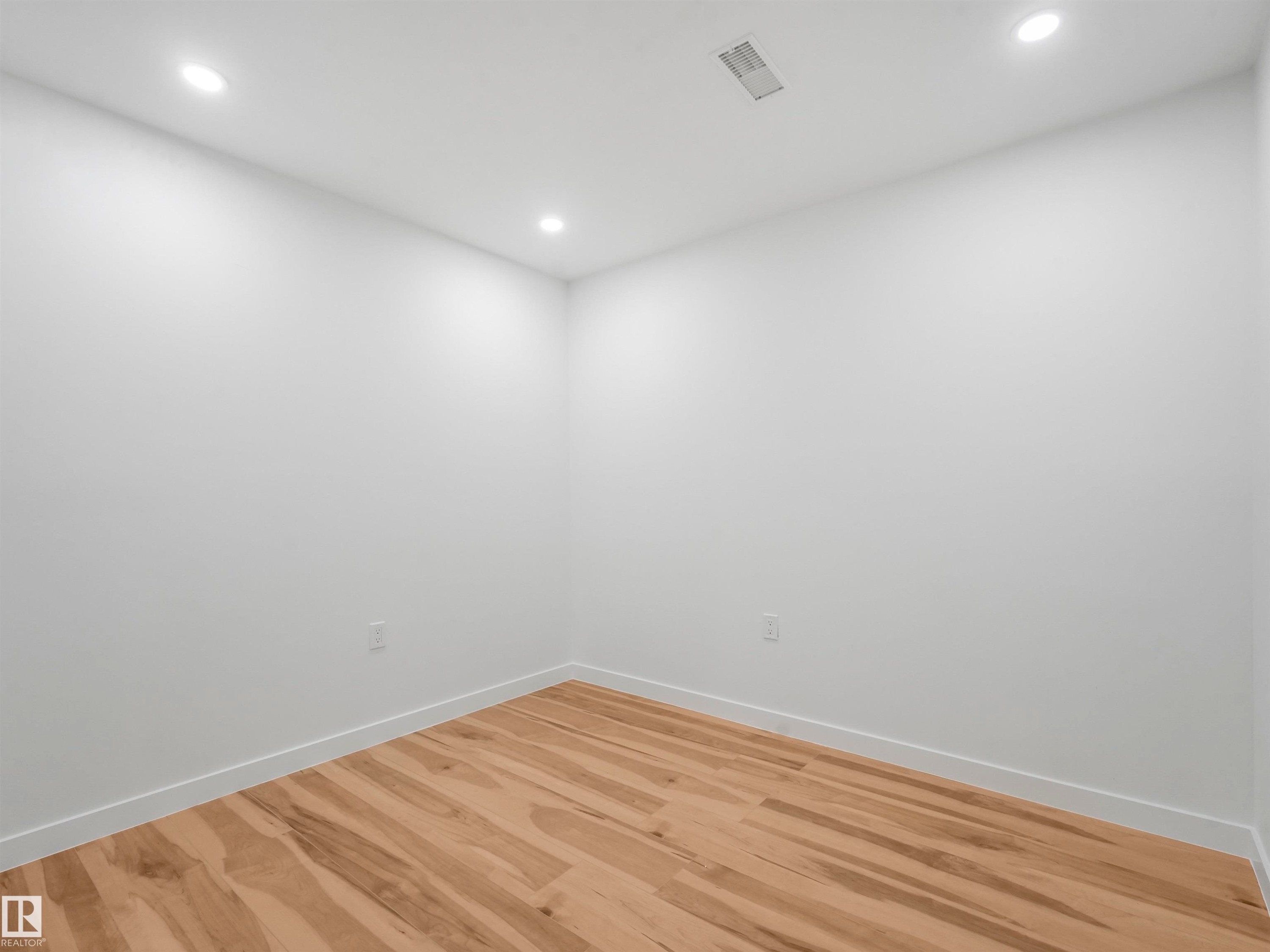 Room featuring light wood-finish flooring, white walls, recessed ceiling lighting, and a ceiling air vent - 17171 38 Street, Edmonton, AB