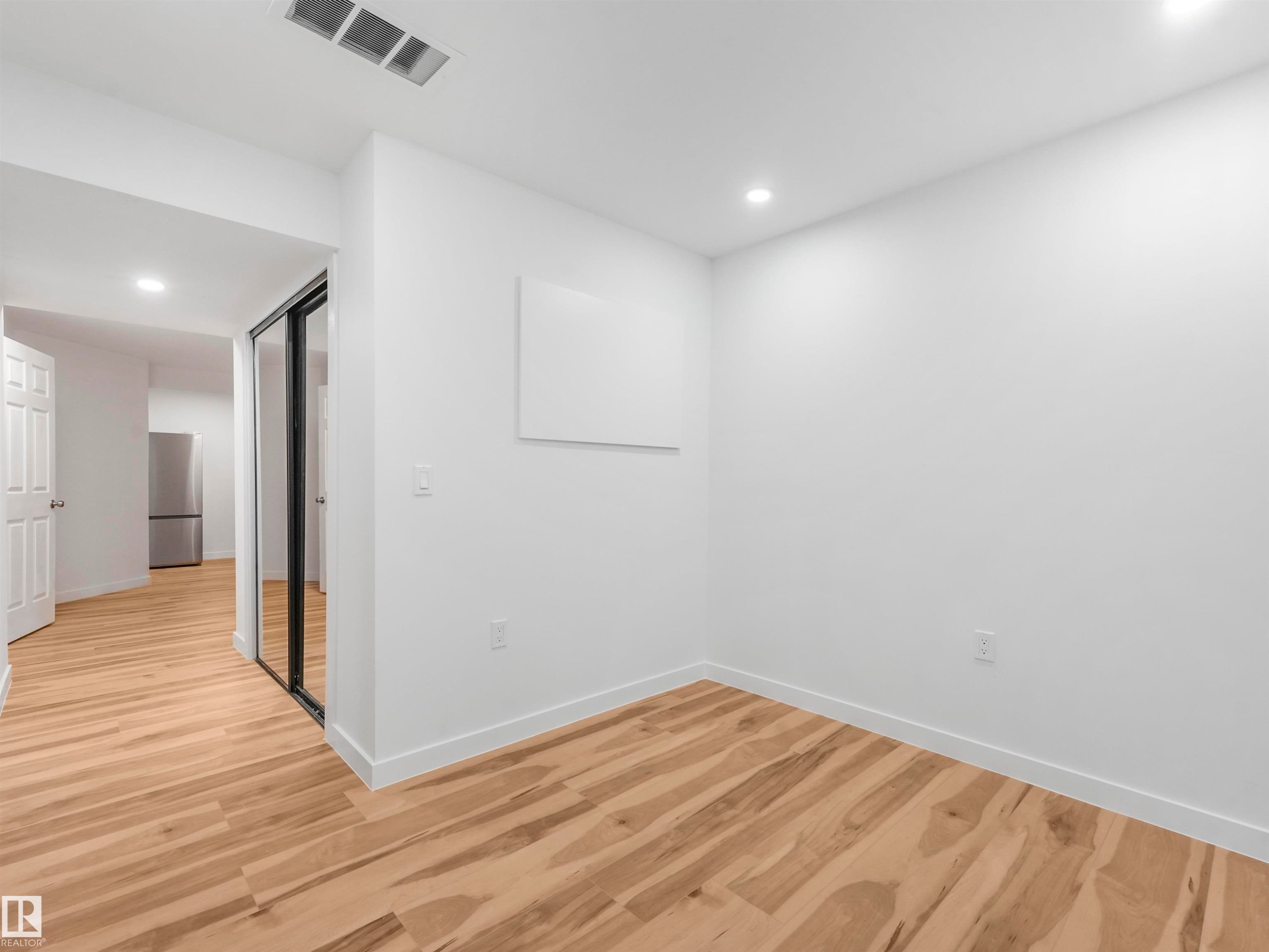 Room featuring wood-finish flooring, recessed lighting, and white baseboards - 17171 38 Street, Edmonton, AB