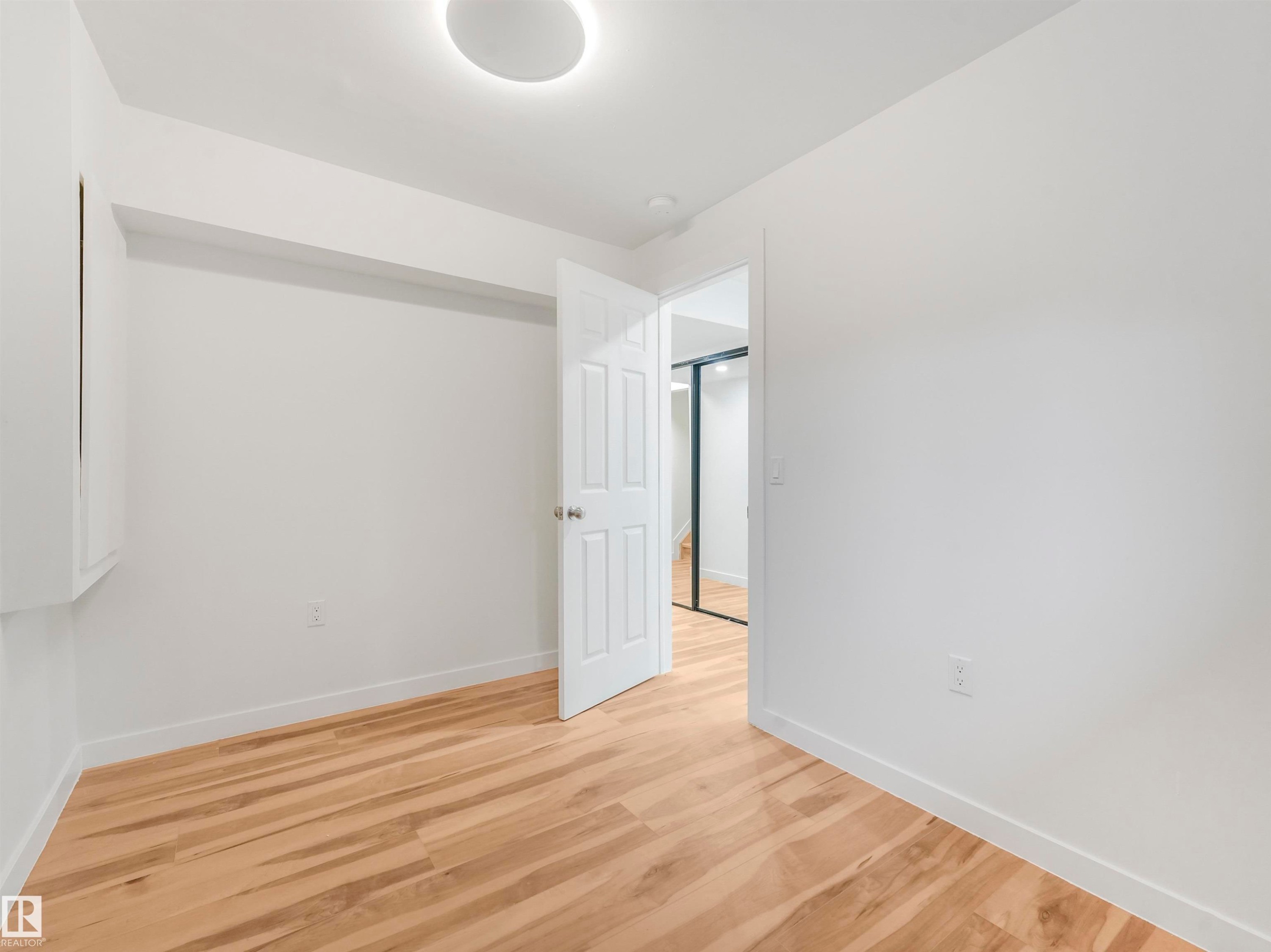 Light wood-finish flooring complements white walls - 17171 38 Street, Edmonton, AB