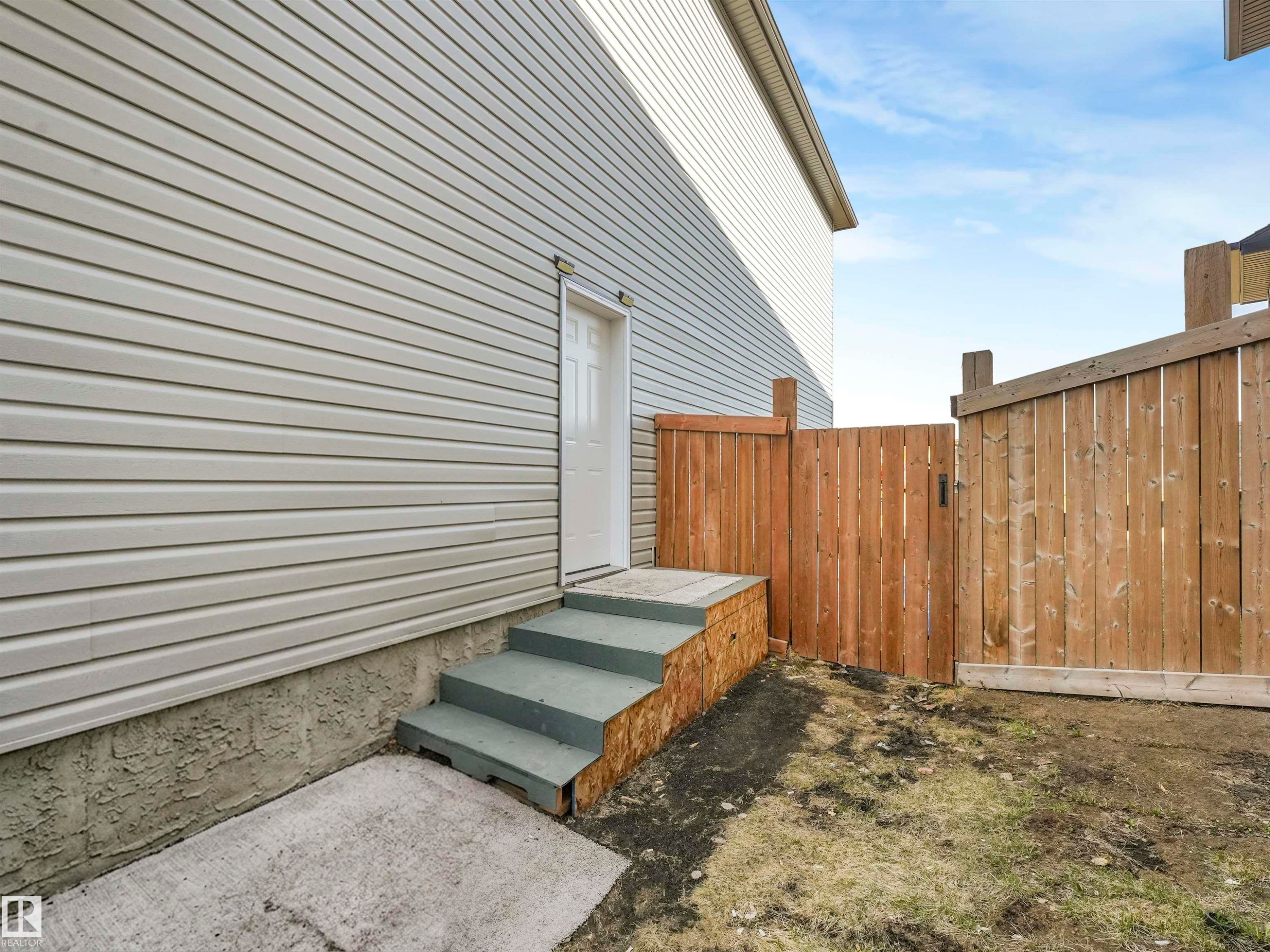 Exterior featuring horizontal siding, a white entry door, and concrete steps - 17171 38 Street, Edmonton, AB