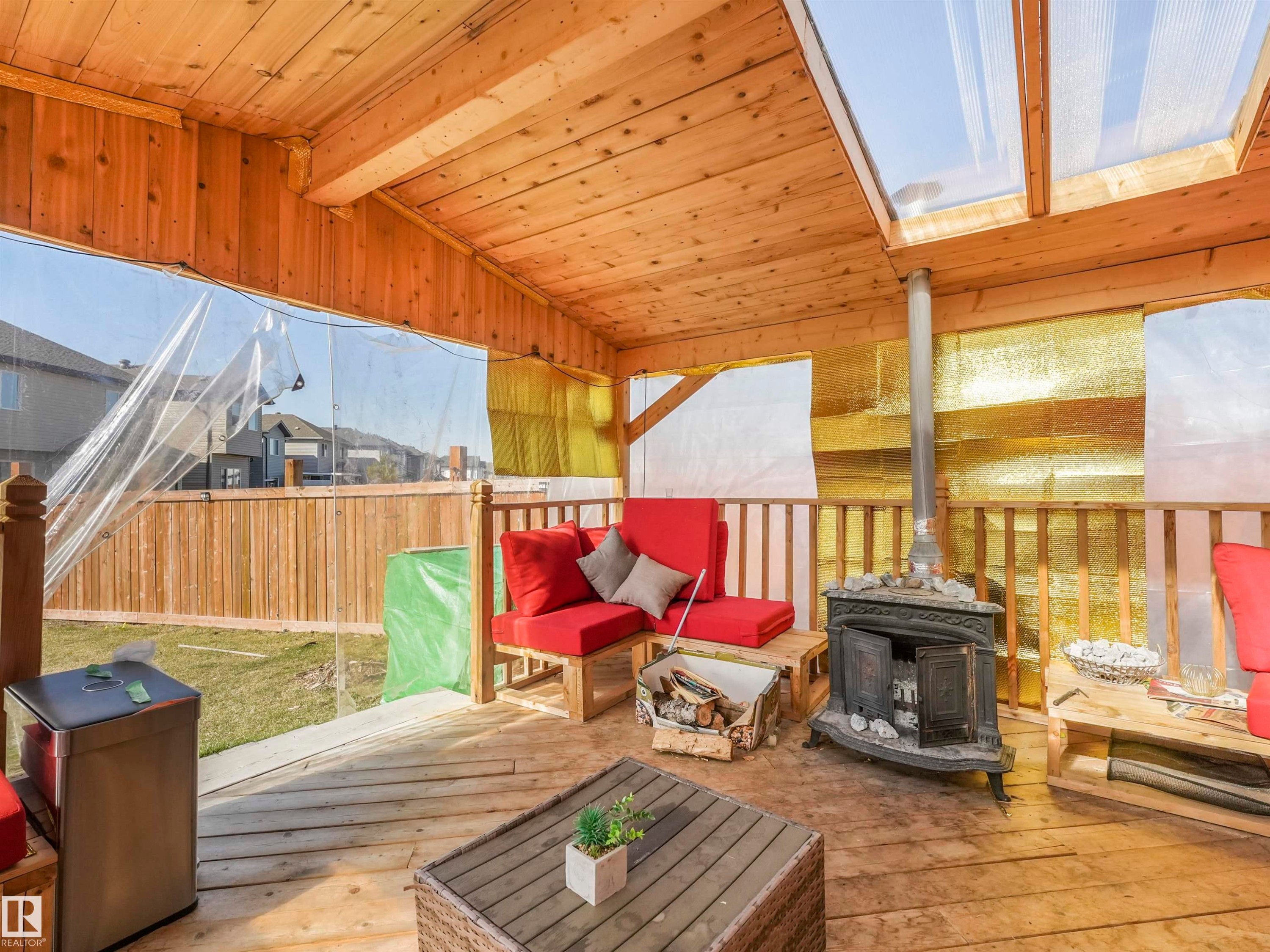 Covered outdoor deck featuring natural wood-finish flooring, ceiling, and railings - 17171 38 Street, Edmonton, AB