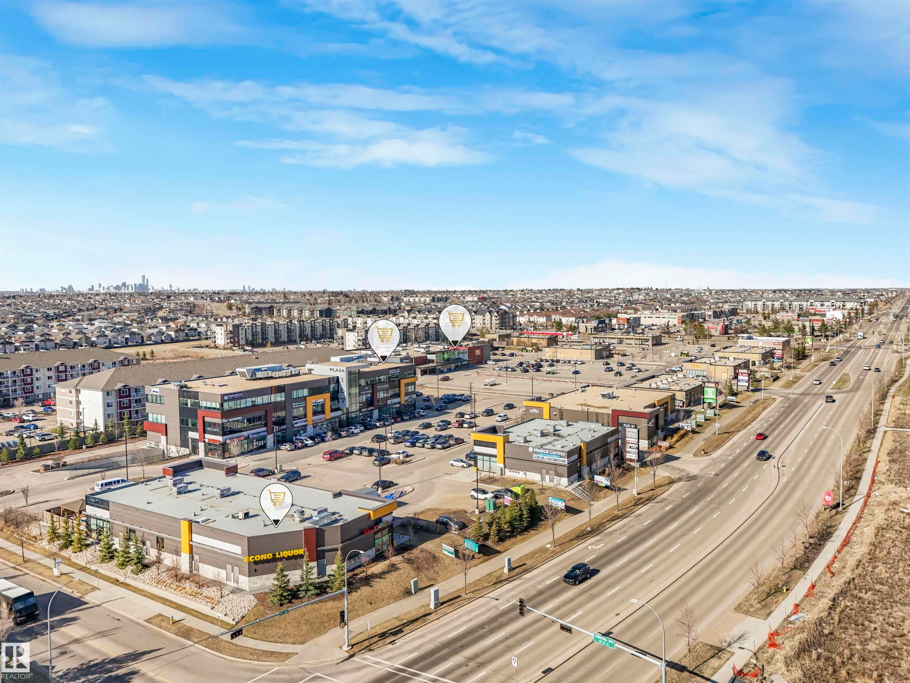 Commercial development featuring multiple buildings with varied architectural facades, extensive surface parking, and direct frontage on a multi-lane thoroughfare - 17171 38 Street, Edmonton, AB