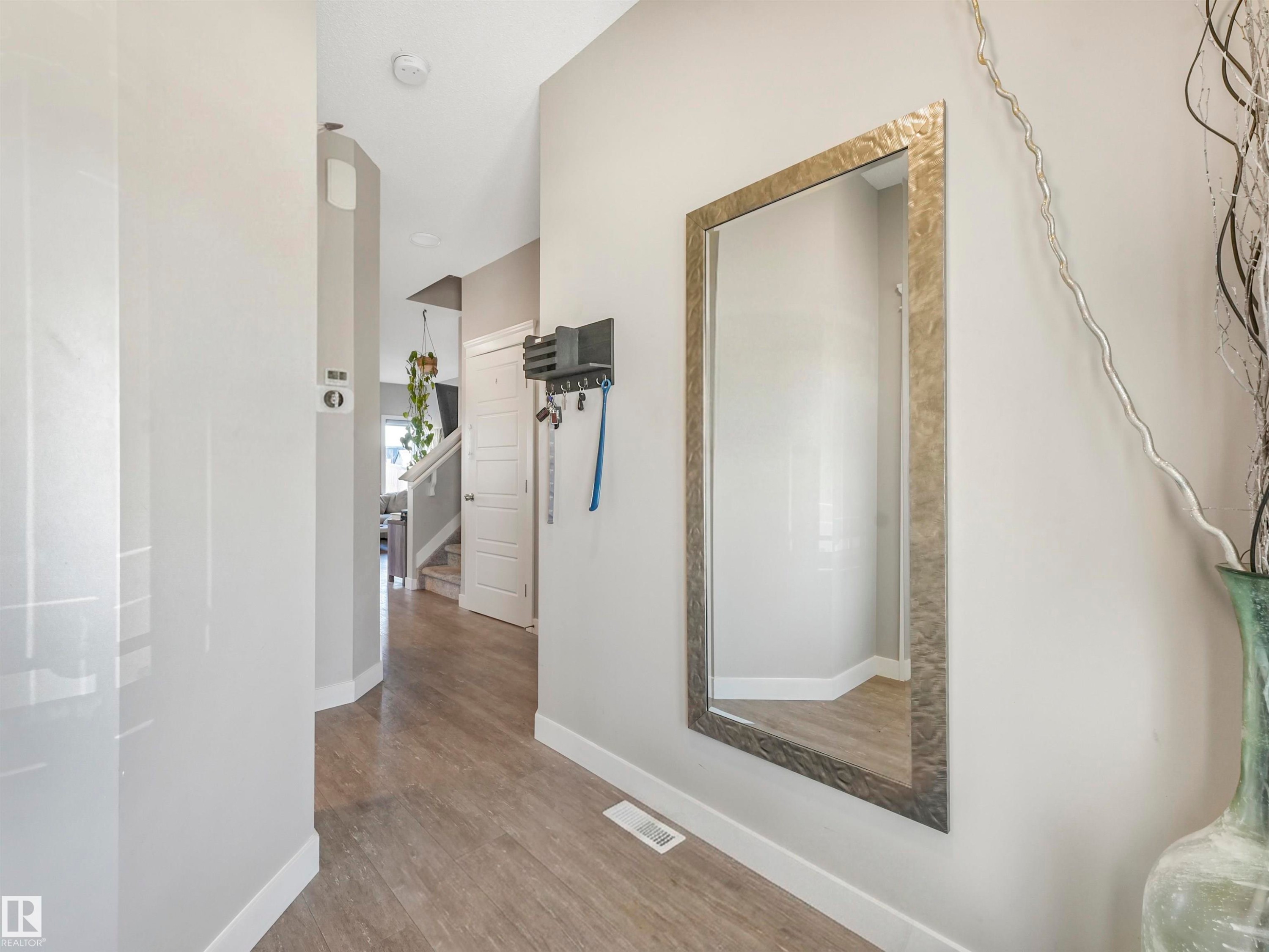 Entryway featuring wood-finish flooring, light gray wall paint, and white baseboards - 17171 38 Street, Edmonton, AB