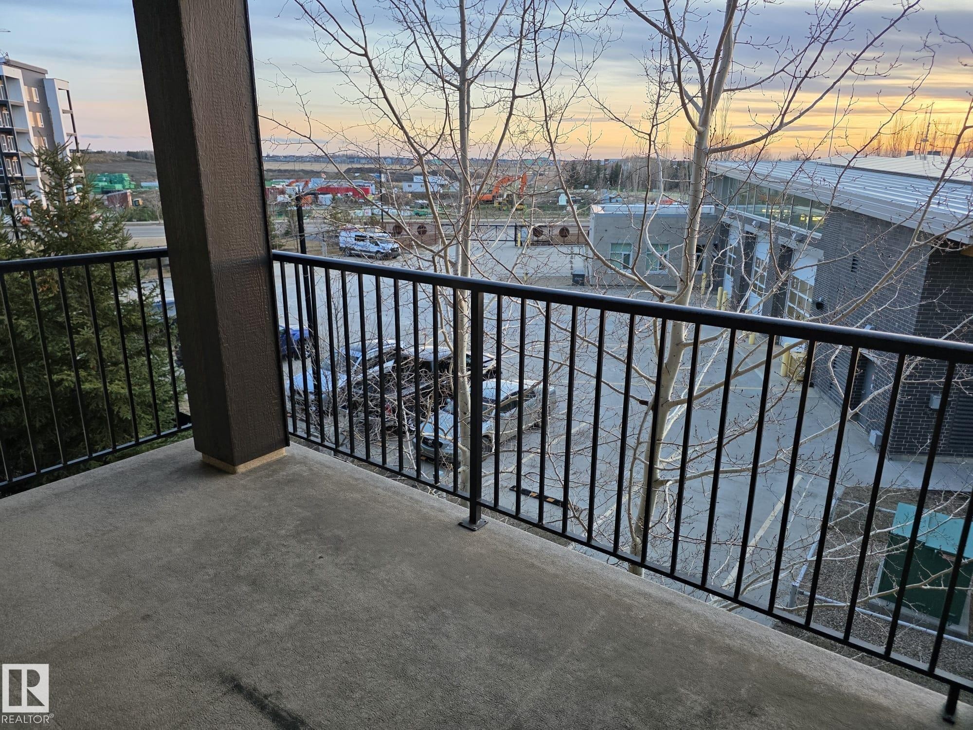 Balcony with concrete flooring and black metal railings - 206 12045 22 Avenue, Edmonton, AB