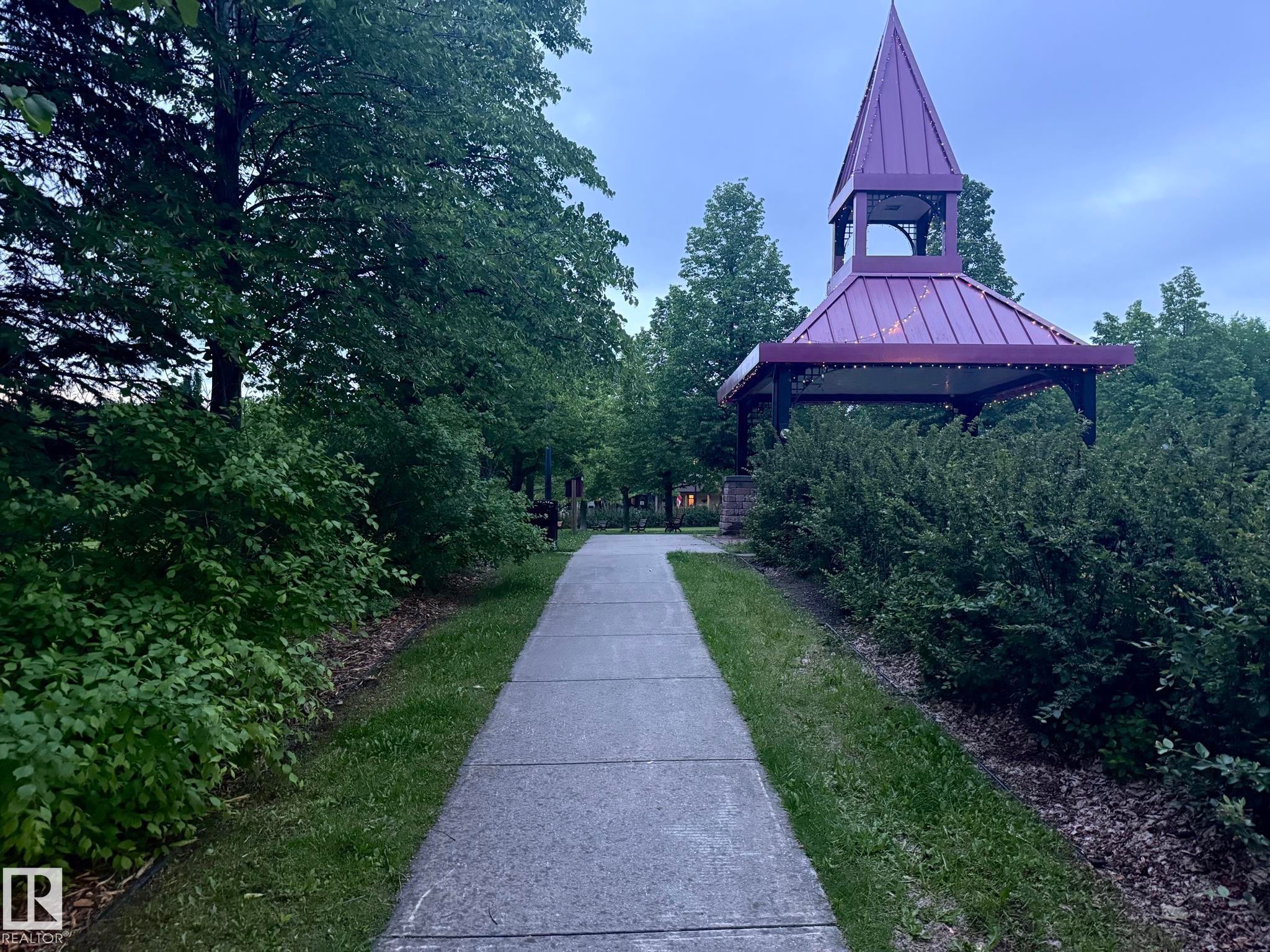 Purple-roofed gazebo featuring a spire and decorative lighting, surrounded by mature trees and manicured shrubbery - 1978 Tomlinson Green Green, Edmonton, AB