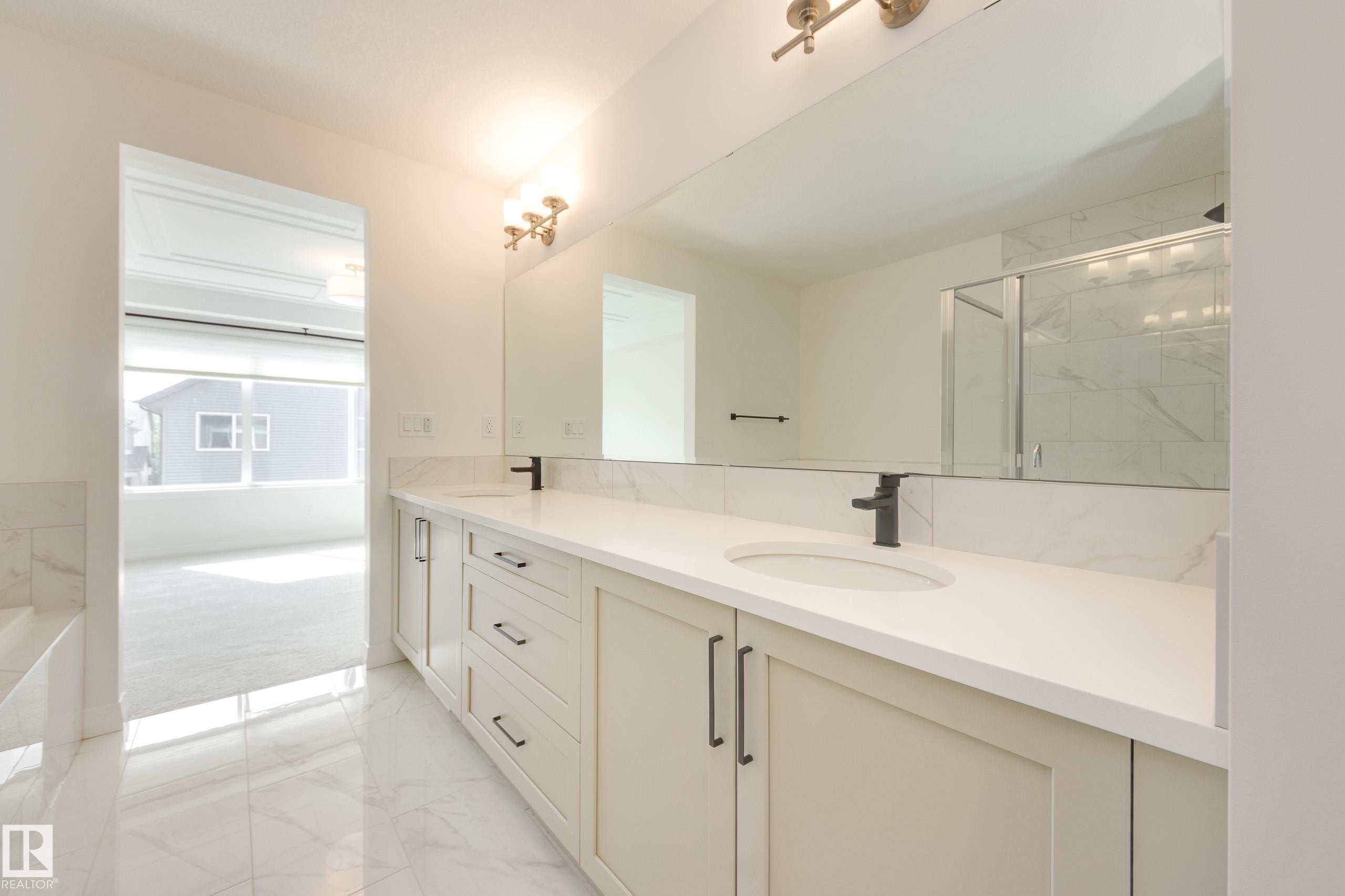 Double vanity with light cabinetry, quartz countertops, and matte black fixtures - 3249 Dixon Way Sw, Edmonton, AB