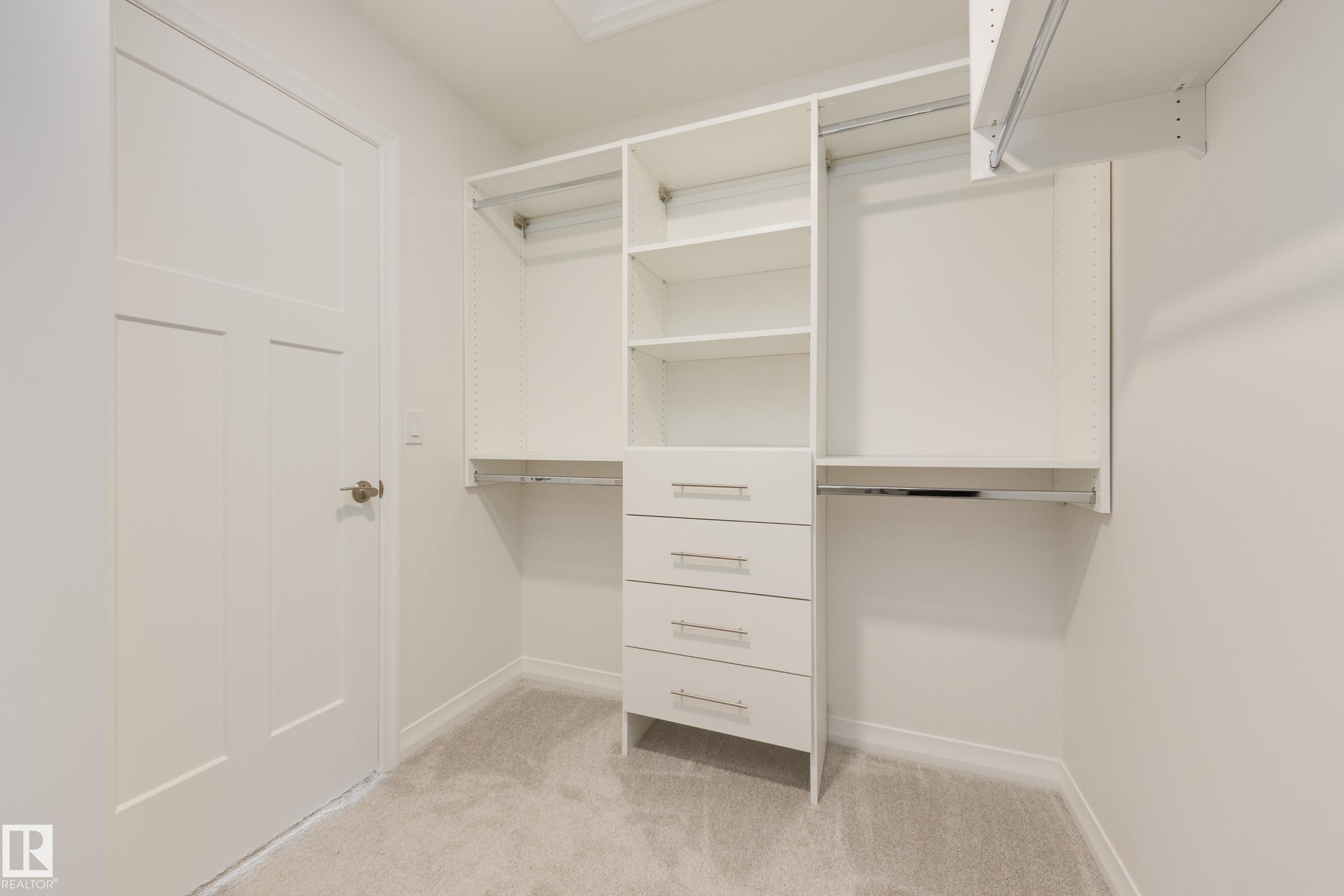 Built-in closet organization system featuring shelving, multiple hanging rods, and pull-out drawers - 3249 Dixon Way Sw, Edmonton, AB