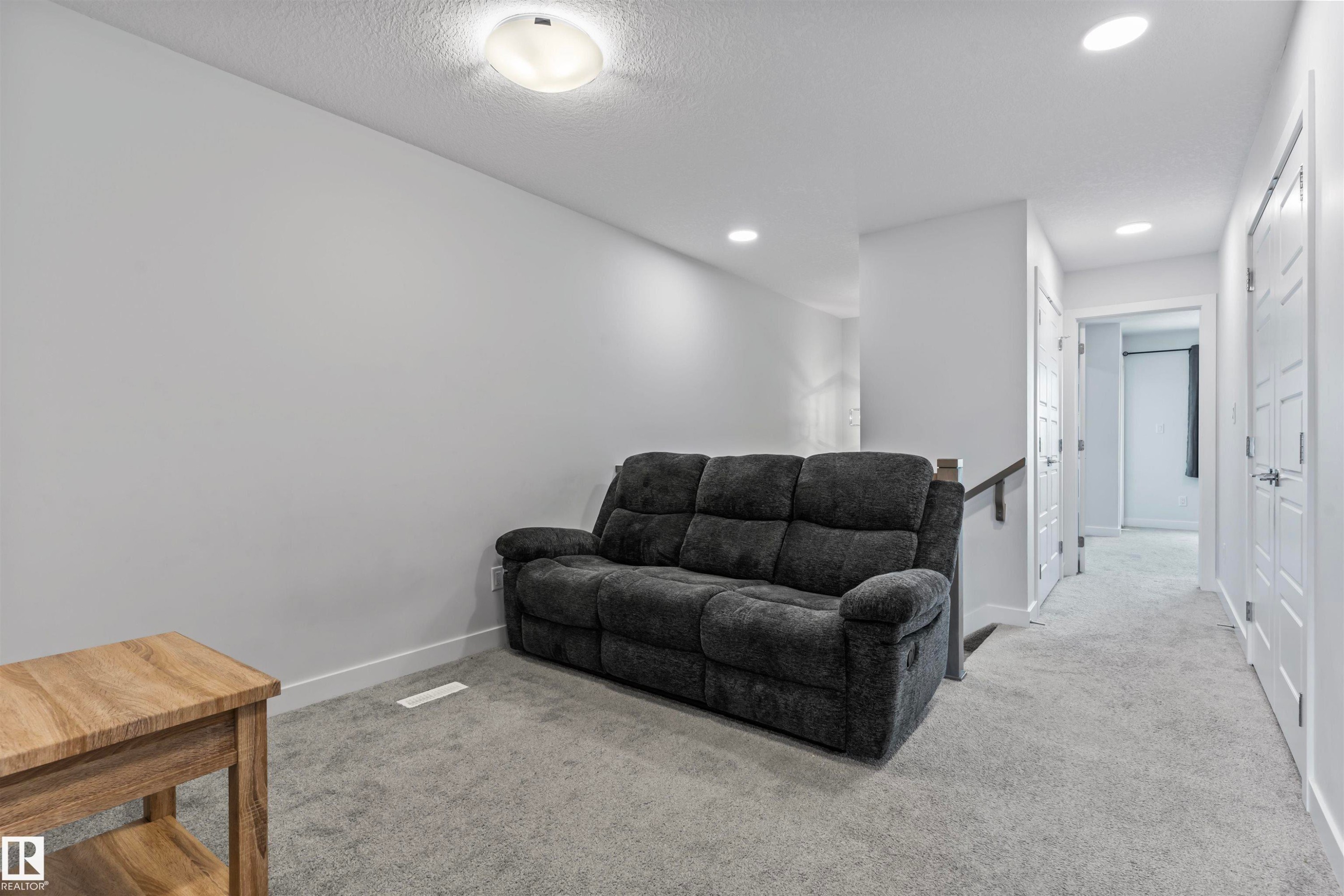 Upper-level bonus room featuring plush grey carpeting, recessed lighting, and a neutral wall palette - 8046 Kiriak Link, Edmonton, AB - Indoor