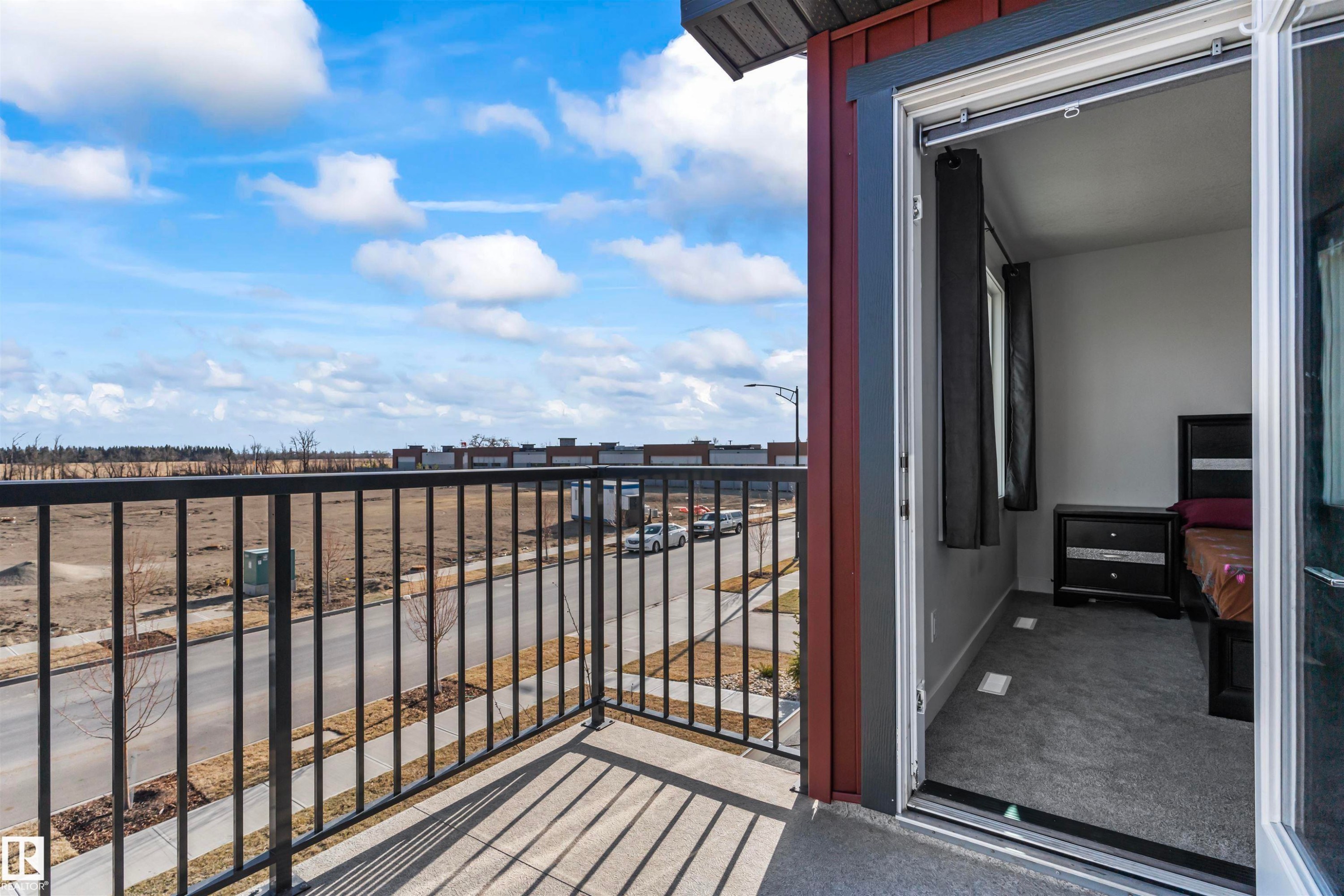 Private balcony with concrete flooring and black metal railings, offering open-air access from an interior space featuring gray carpet flooring and white walls - 8046 Kiriak Link, Edmonton, AB - Outdoor With Balcony With Exterior
