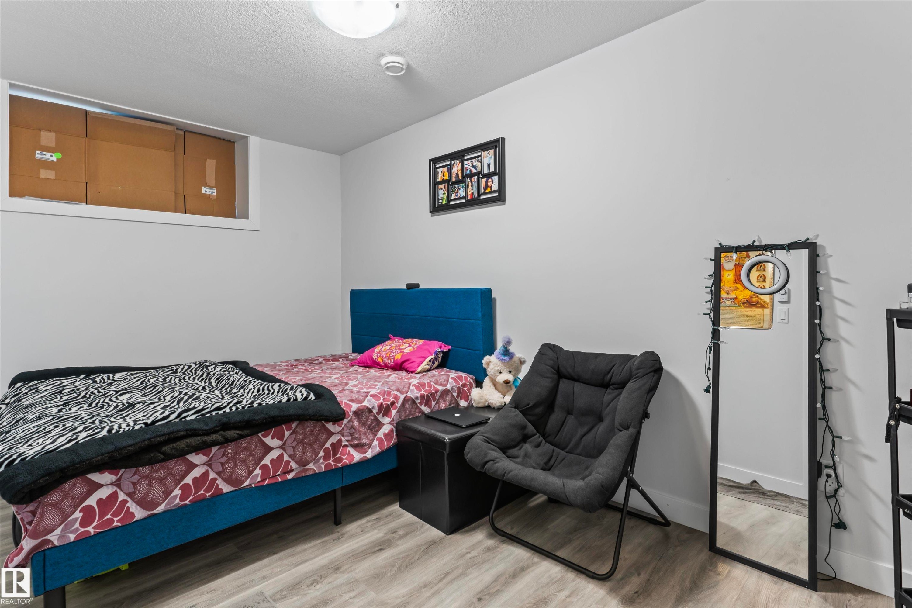Room featuring light gray walls, wood-finish flooring, and a flush-mount ceiling light - 8046 Kiriak Link, Edmonton, AB - Indoor Photo Showing Bedroom