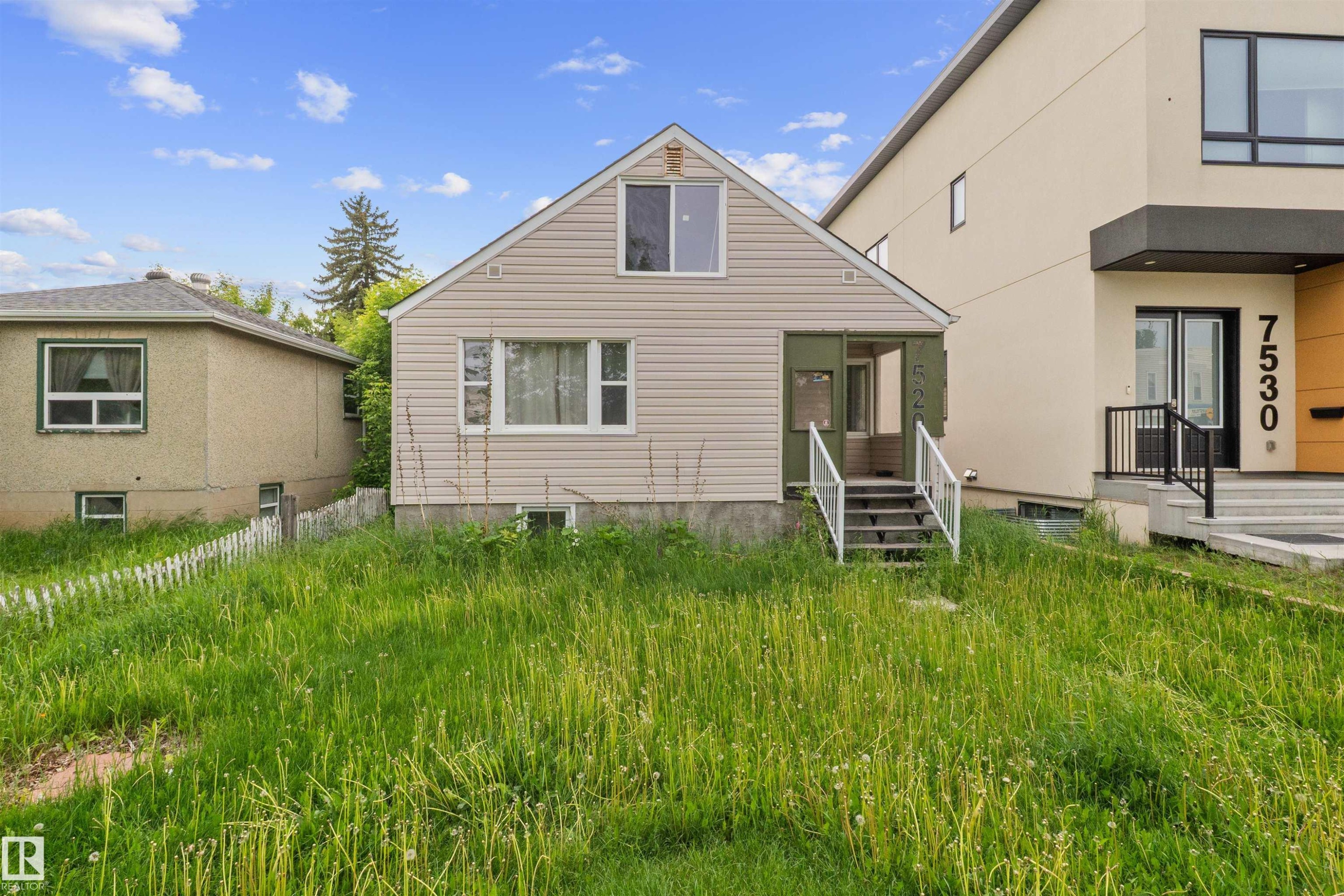 Gabled home featuring light-toned horizontal siding and a covered front entry - 7520 106 Street, Edmonton, AB